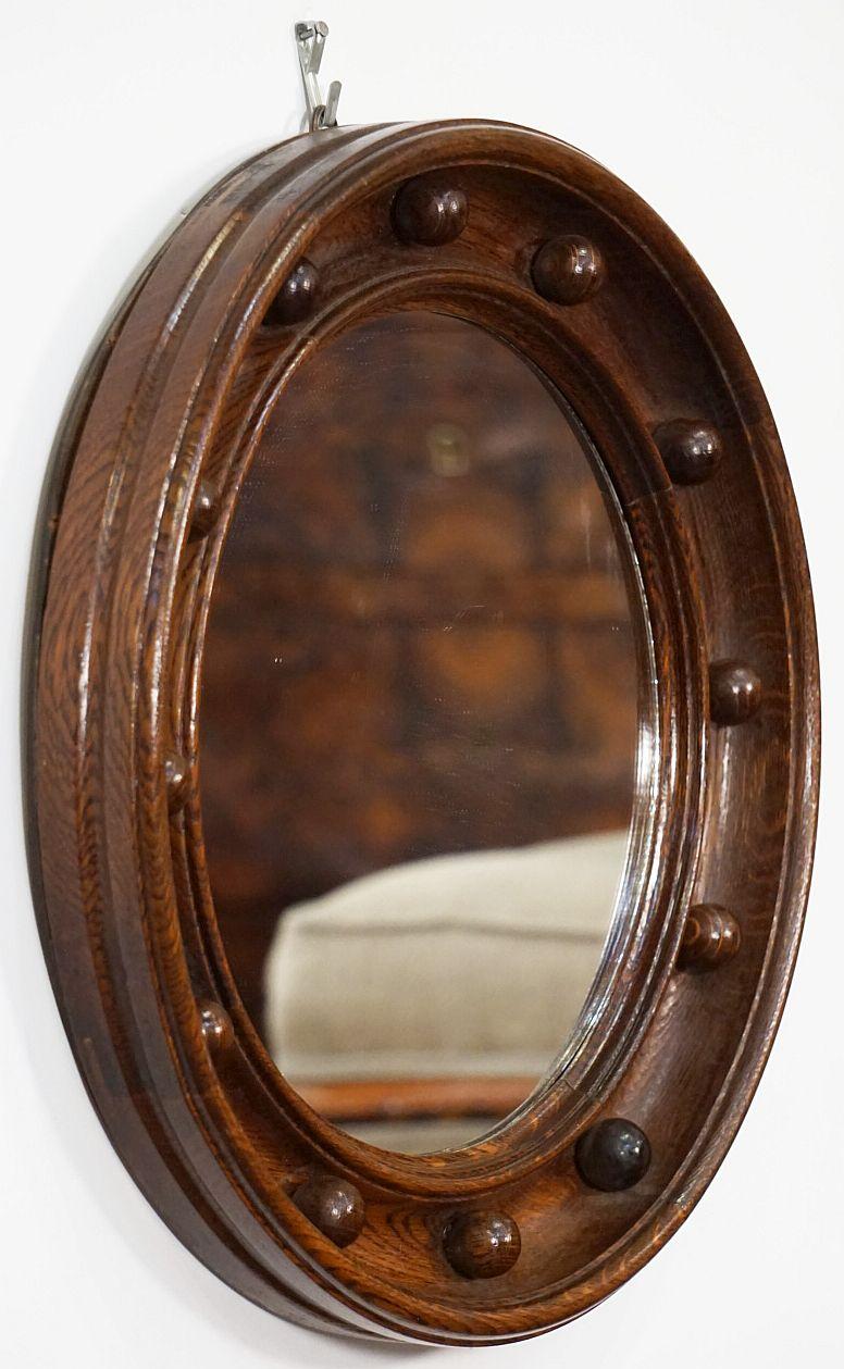 A fine English round or circular mirror featuring a Regency style design of a moulded oak frame with turned balls around the circumference.

Dimensions: Diameter 16 1/2 inches x Depth 2 1/4 inches