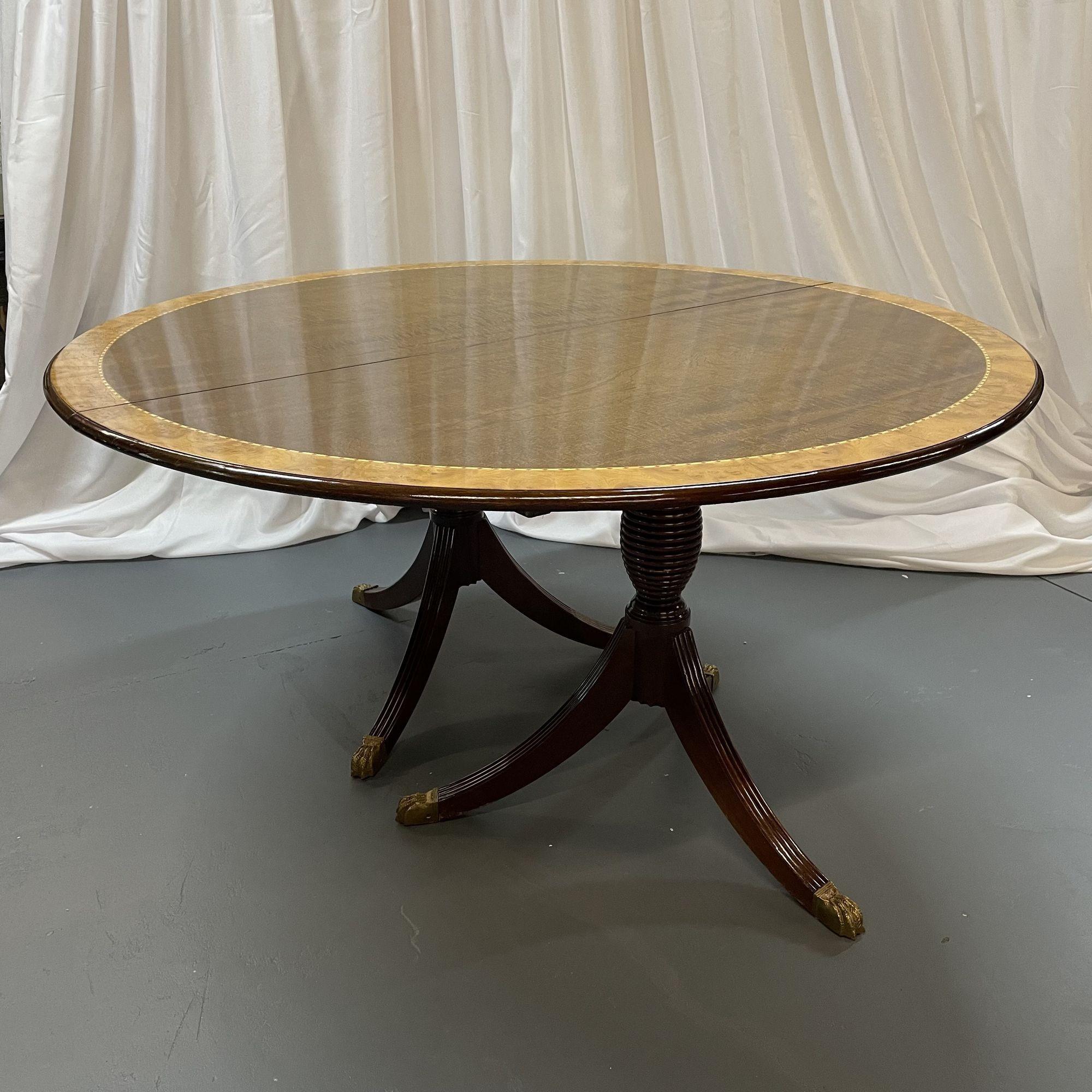 A Sixty Inch Round Regency Style Dining Table with Two 24 inch Leaves. Part of our extensive collection of over forty dining tables and chair sets.

The double tripod base having bronze claw feet supporting a flame mahogany satin wood banded and