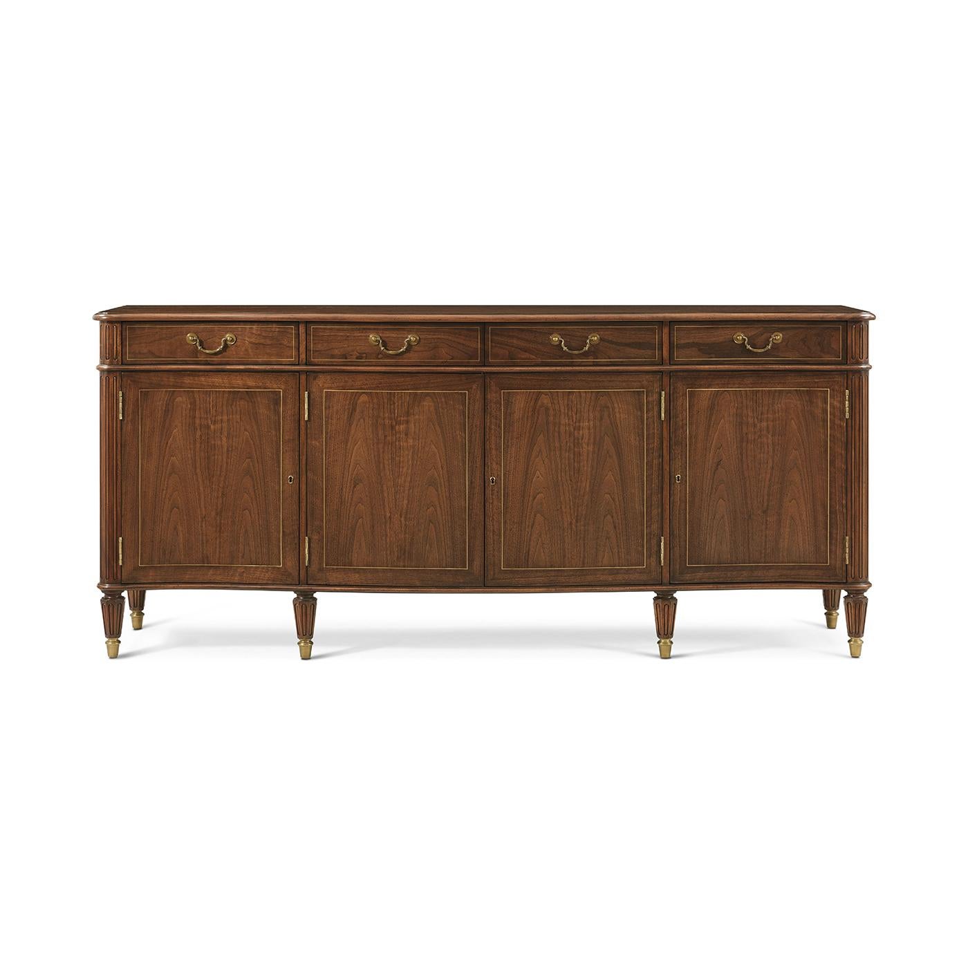 Meticulously crafted to reflect the refinement of early 19th-century English design. Made from beautifully figured wood in a warm walnut finish, it features four paneled doors with fine brass inlay and flanked by reeded quarter column stiles. The