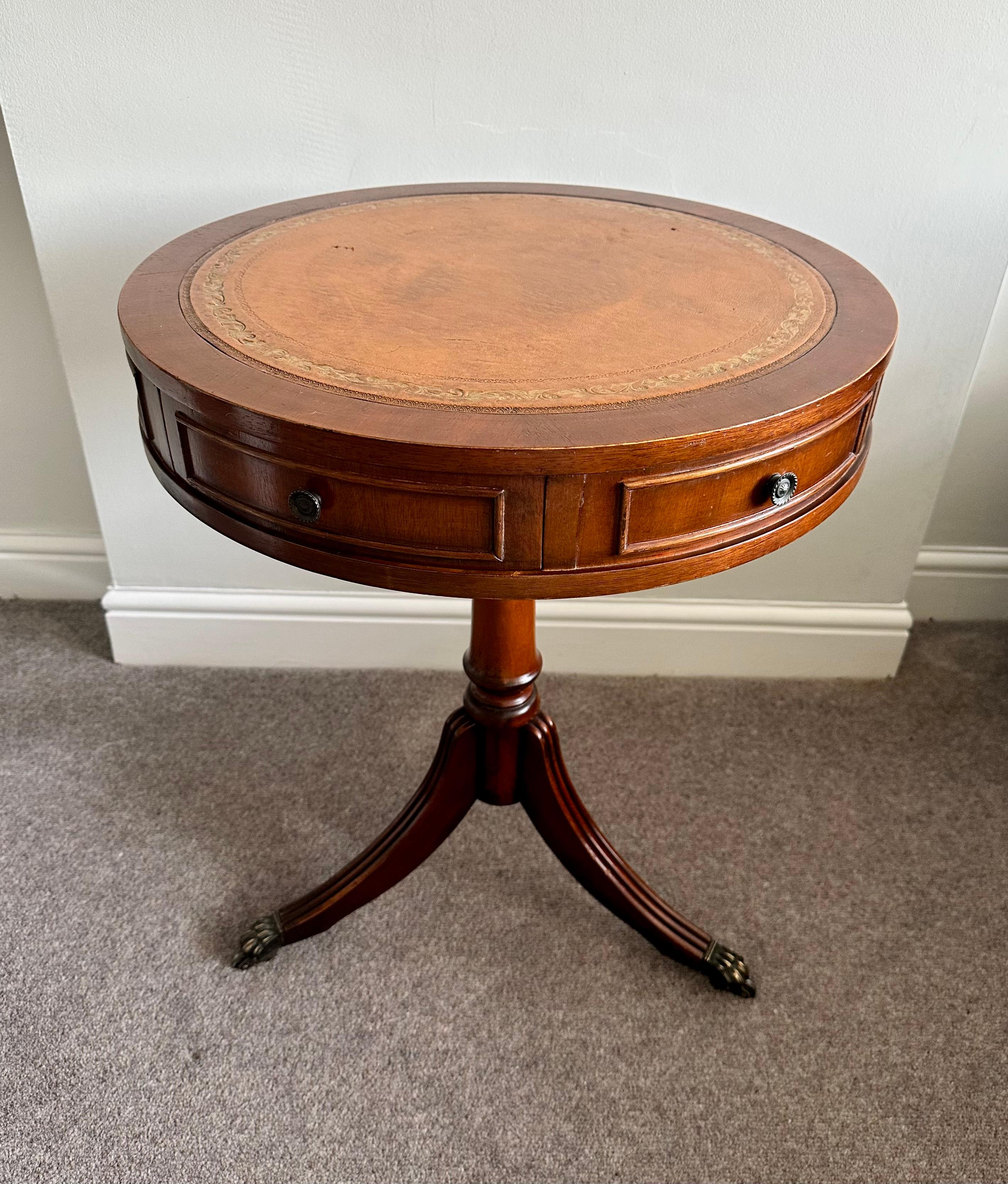 Here we have for sale this lovely Regency style drum table with mahogany frame and tan leather top. 

A very good looking well made and decorative piece, ideally suited as a lamp wine or side table. It has been lightly restored to include a clean