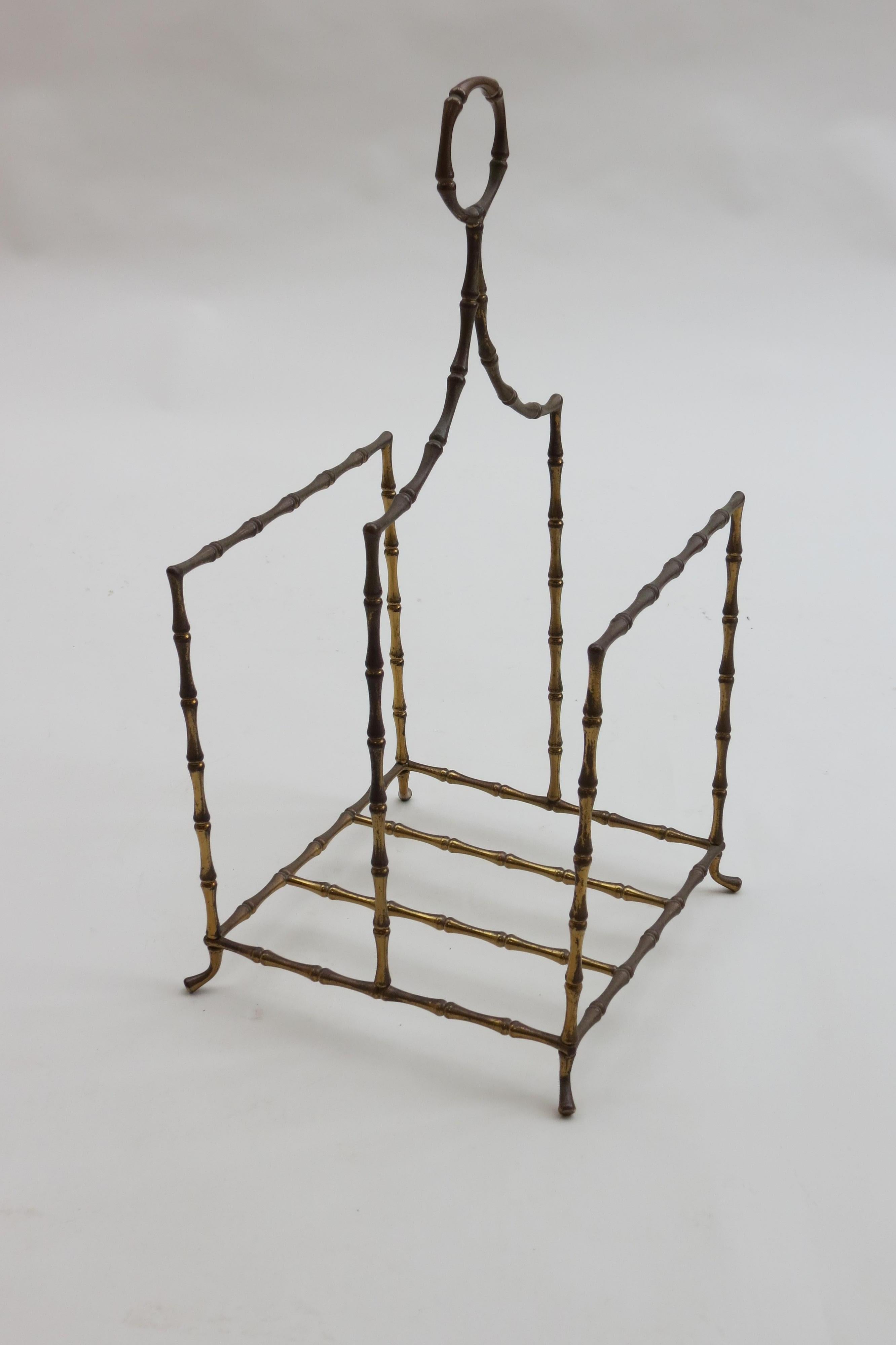 1960s magazine rack in the Regency style. Made from solid brass simulating bamboo. This piece is heavily patinated and the finish is worn, this adds to the appeal of the piece. 

 