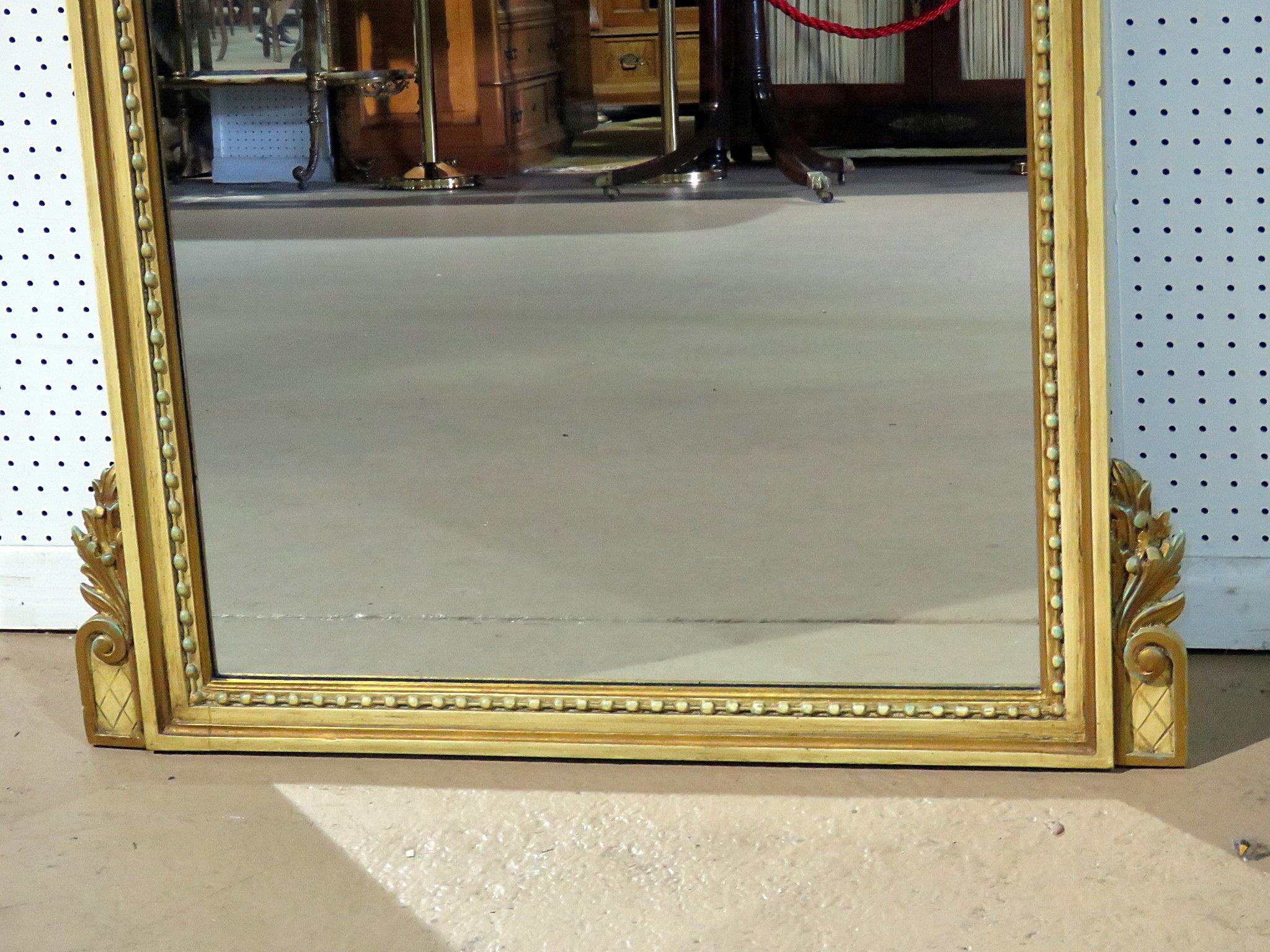 This beautiful mirror is done in a gold carved frame with a theme of the harvets. The shovel and rake shown corssing each other with the flowers in the foreground, symbolize a bountiful life, good fortune and prosperity. The mirror is in good