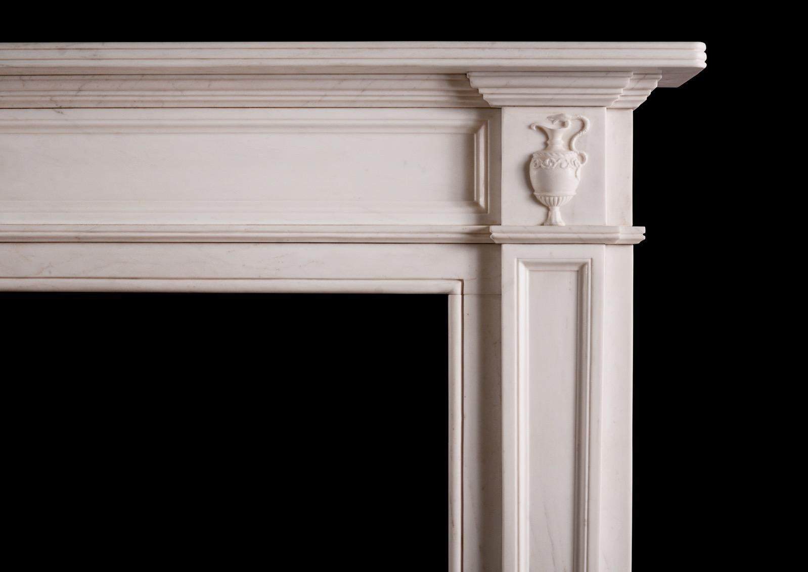 A Regency style fireplace in white marble. The tapering panelled jambs surmounted by classical urns to side blockings, the panelled frieze surmounted by reeded shelf above. A copy of an earlier piece.

N.B. May be subject to an extended lead time,