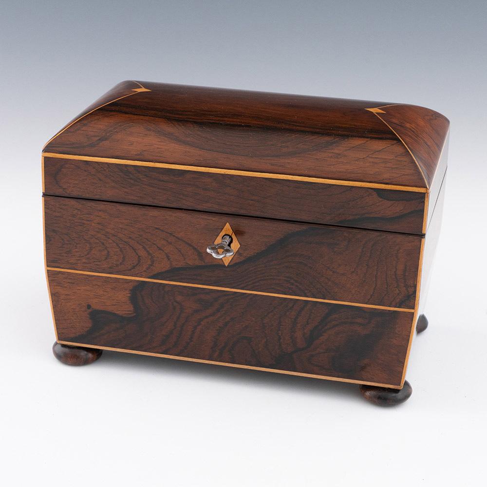Heading : Sarcophagus shaped Regency tea caddy c1820

Date : c1820

Period : Regency

Origin : England

Decoration : Modified sarcophagus shape with curved cover. Four applied bun feet. Diamond shaped escutheon. Strining with inlaid diamond