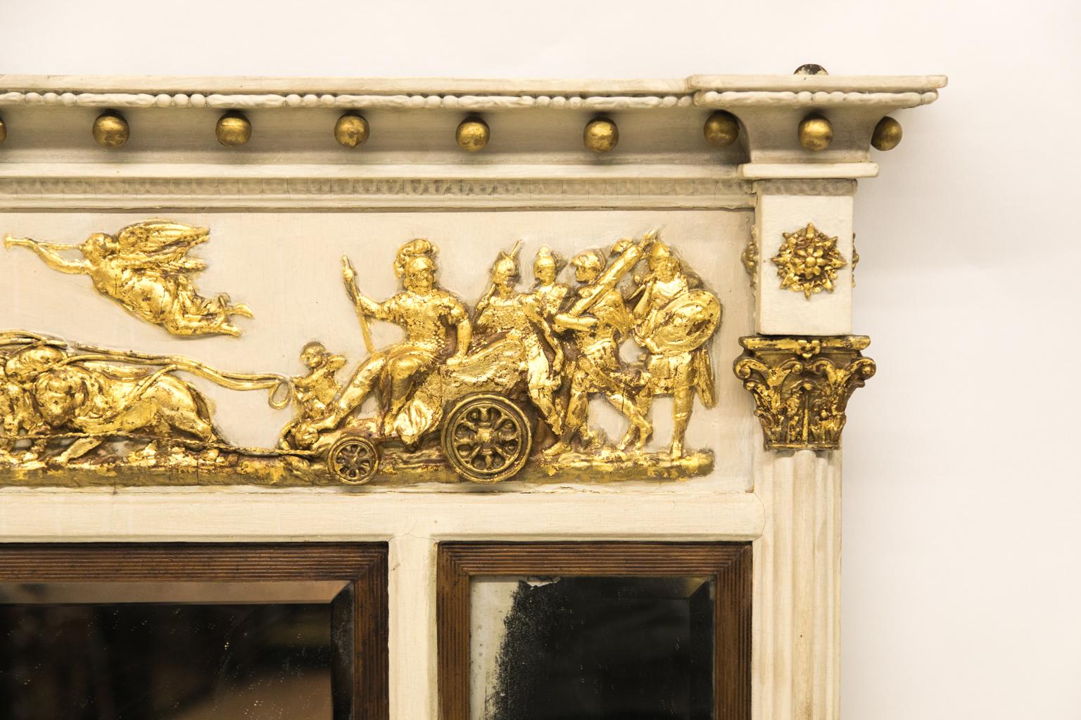 Regency three panel mirror, the frieze is carved in high relief with gilt angels and lions pulling the classical chariot with warriors.
 
