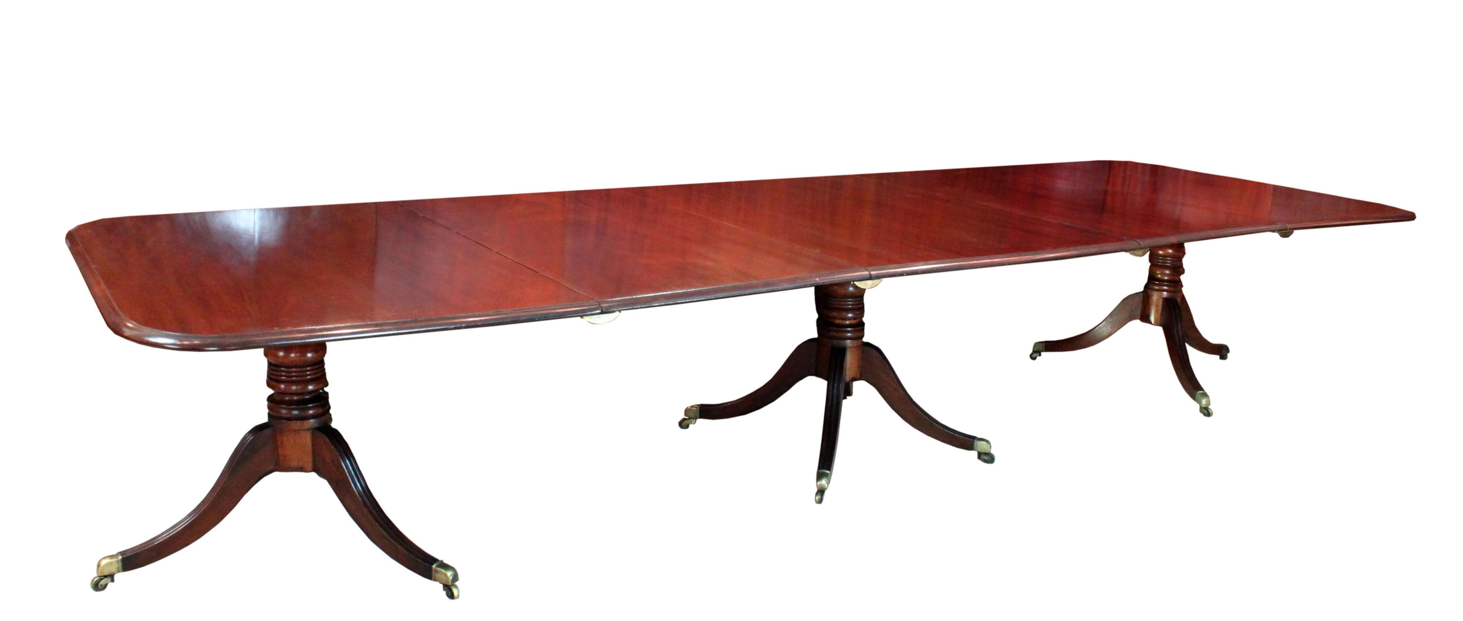 A fine Regency three pillar table in figured mahogany. Good model with generous sized tops, square ends and the combination of a four splay centre base and tripods at the ends making for comfortable seating. The bases with reeded sabre legs and