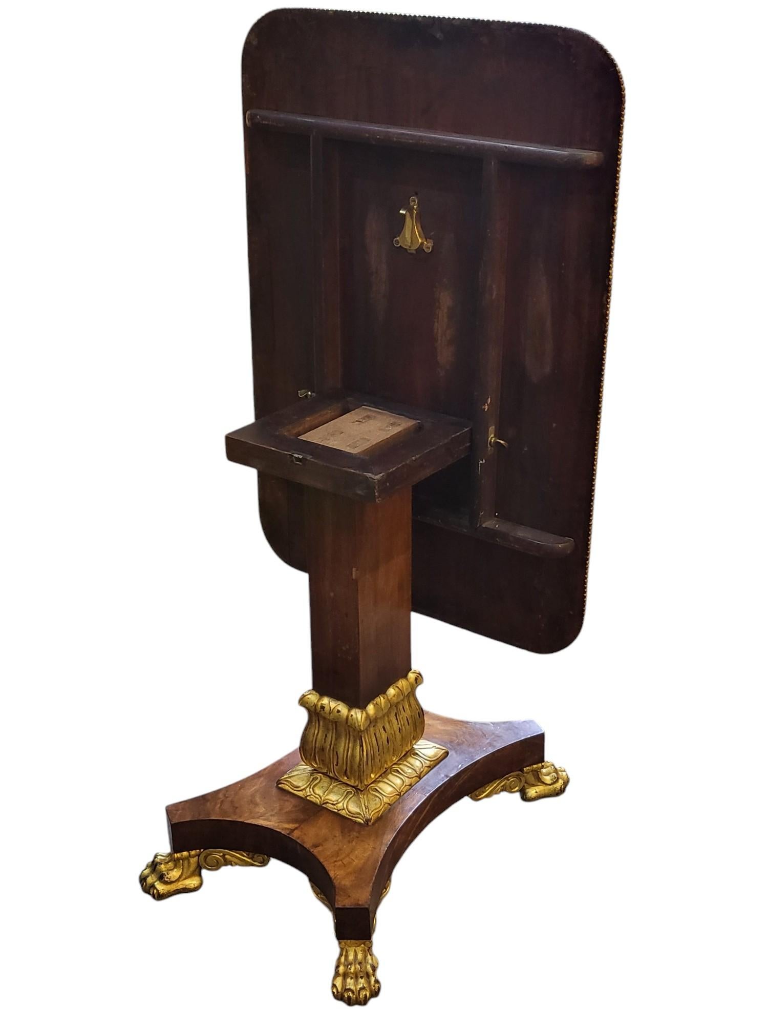 Magnifique table de style Regency à plateau basculant 
Acajou à bandes croisées
Ravissante colonne à la taille avec feuilles de lotus dorées sur une base quadripartite et des pieds en chignon
Daté des années 1820