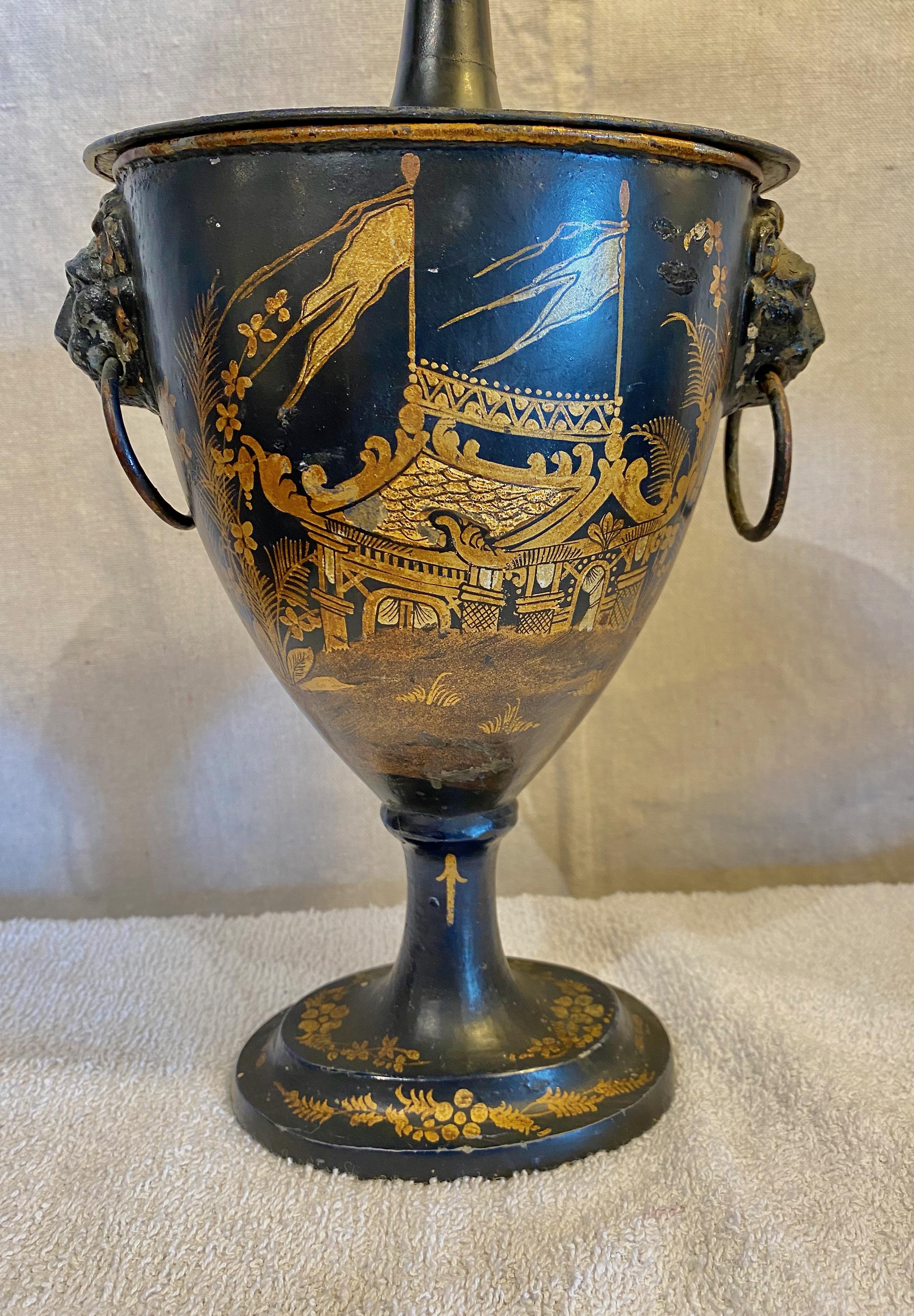 This is a very good example of an early 19th c. Regency Tole Chestnut Urn . The black urn is finely decorated in Chinese motifs with lion head and ring side handles. The painted decoration, which remains in very good condition, depicts naval scenes.