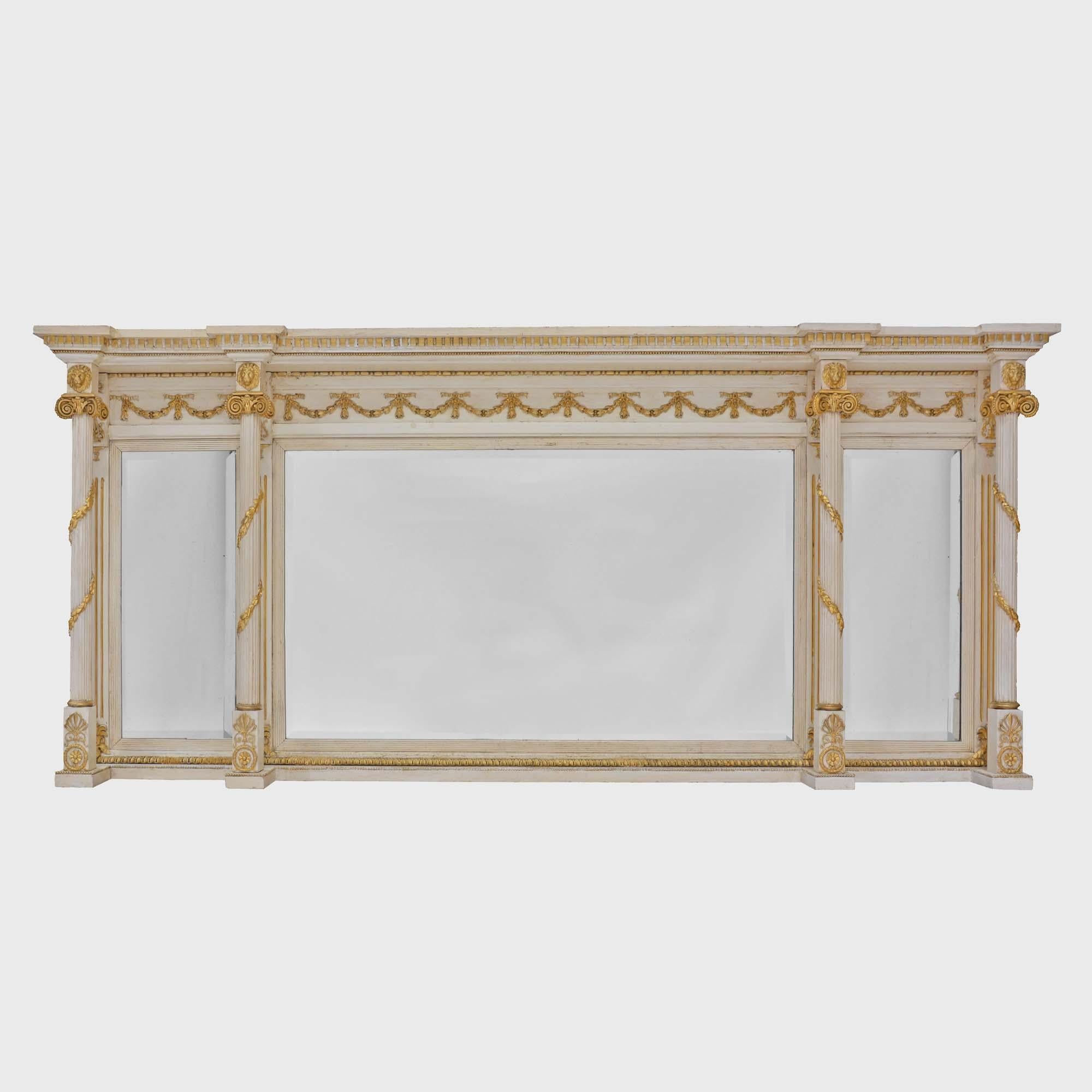 Trittico di specchi dorati e dipinti di bianco
Specchiera Regency a sovramontatura, quattro colonne scanalate decorate con fasce dorate di foglie d'acanto montate con maschere di leoni in stile Adams sotto un fregio a dente di cane, le tre piastre