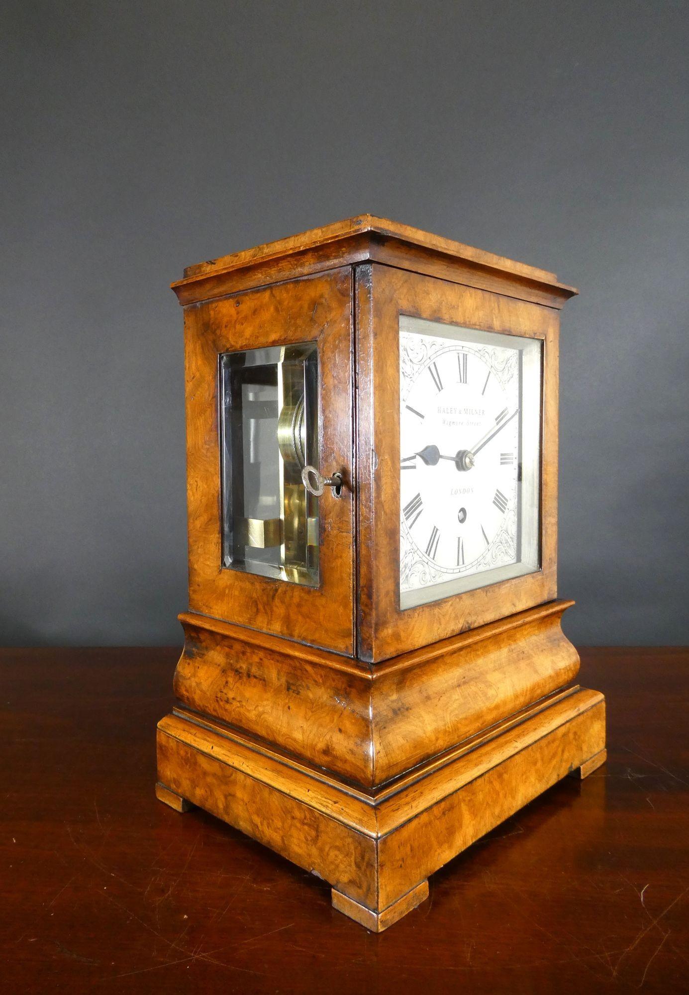 Walnut Library Bracket Clock, Haley & Milner, London
Finely figured walnut 5 glass case with moulded plinth and standing on pad feet with bevelled glass throughout.
Front opening door revealing the silvered dial with Roman numerals, finely engraved