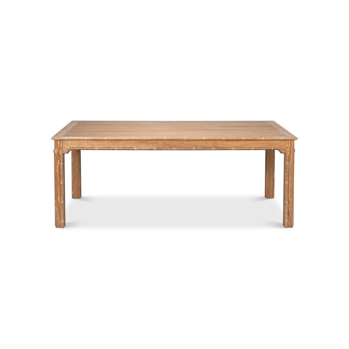 Regency style with a relaxed coastal aesthetic. Crafted with oak, this stunning piece is lightly whitewashed to enhance the natural wood grain, lending it an airy and sophisticated appeal. Delicate bamboo-accented edges and legs evoke a chinoiserie