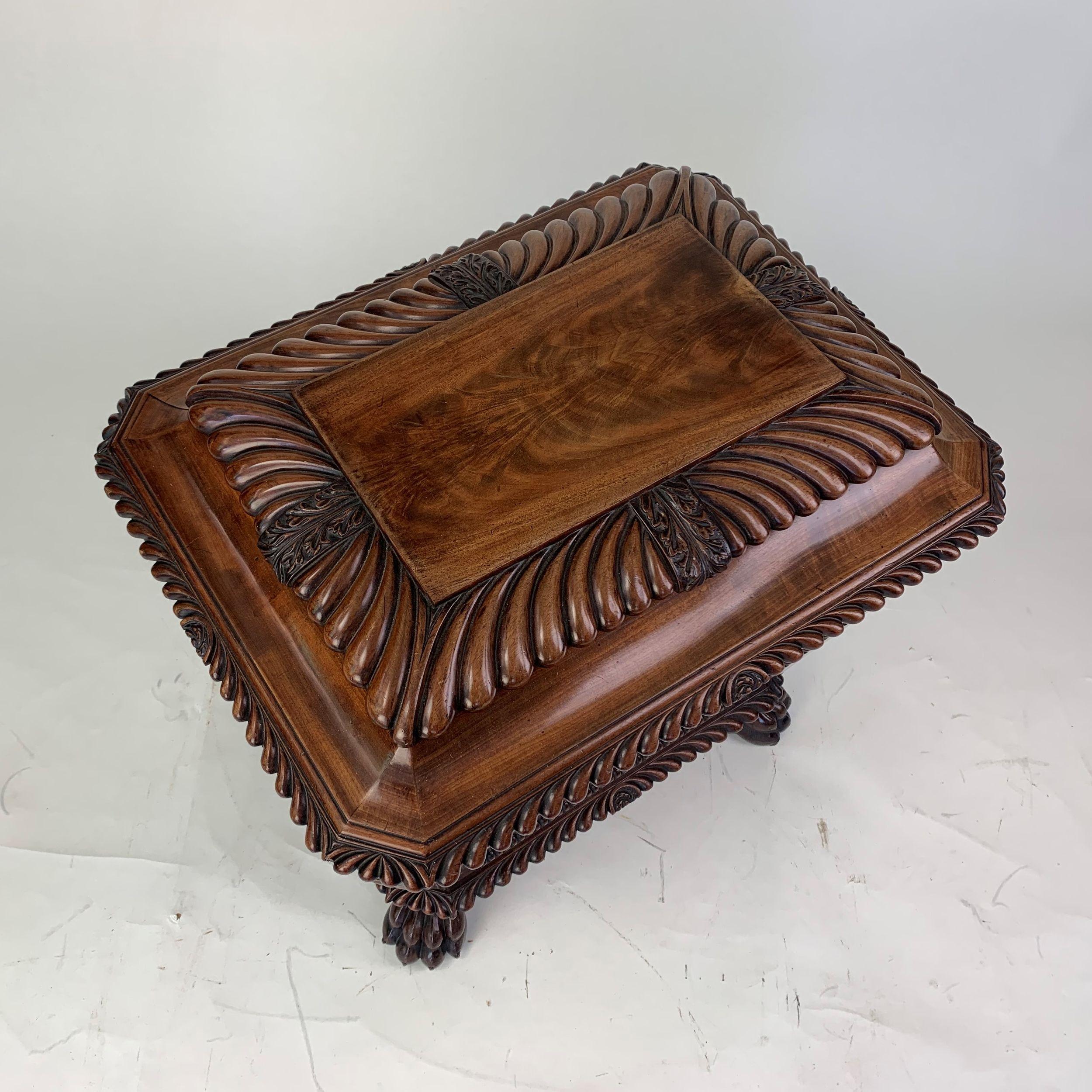 An exceptional and outstanding quality Regency period sarcophagus shaped mahogany wine cooler attributed to Gillows, constructed in the most beautifully figured mahogany and carved all round with symmetrical gadrooning, interspersed with foliate