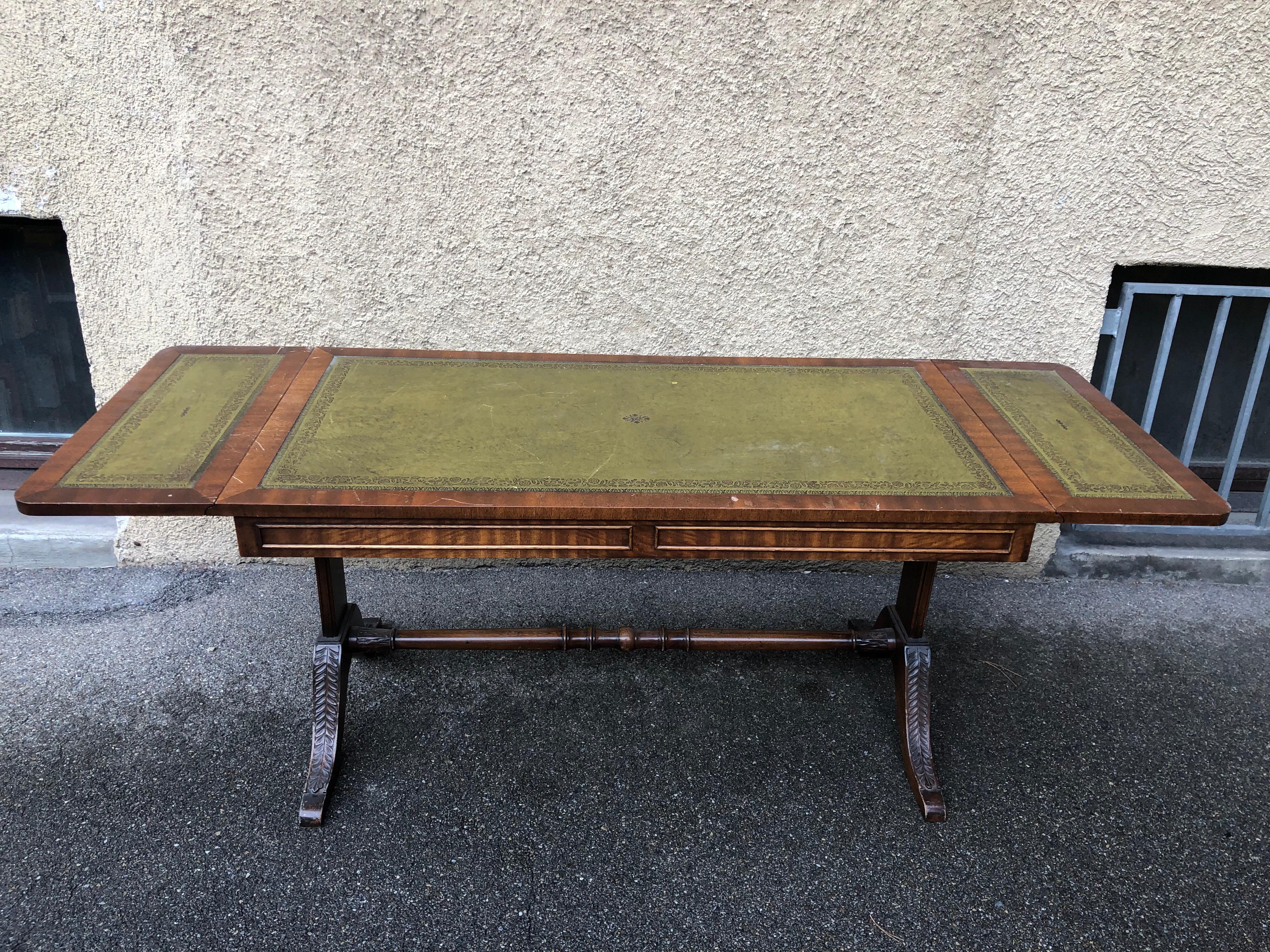 Elegant coffee table in good condition with beautiful leather top , foldable sides and carved details. This table was made circa 1940.

For lower shipping prices, we ship it disassembled.

The Regency in the United Kingdom of Great Britain and
