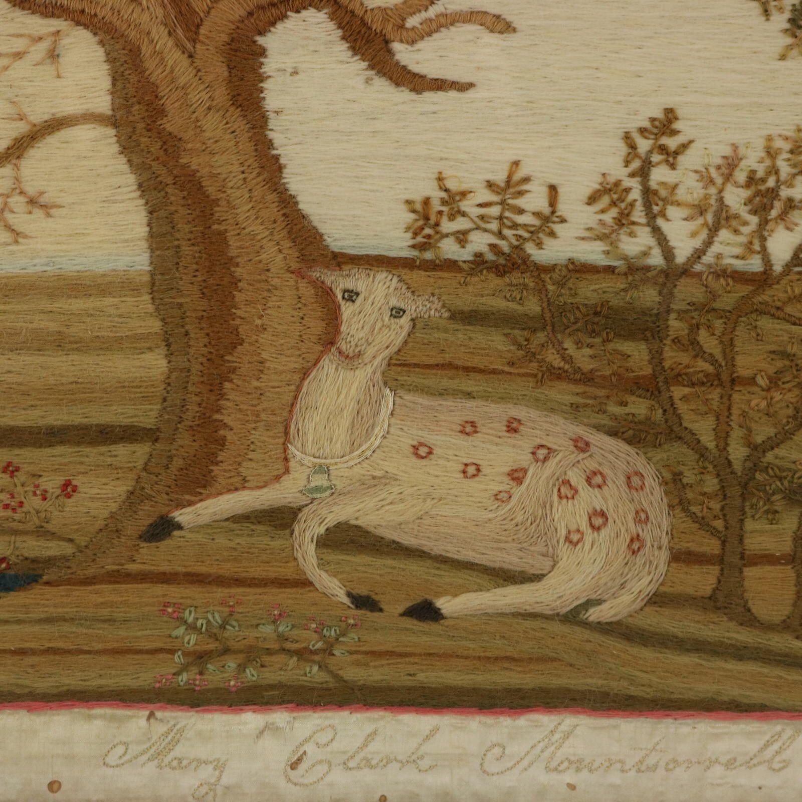 Regency period woolwork embroidered picture of a deer in a country scene. The embroidery is worked in wool on a canvas ground, in a variety of stitches. Pictorial scene depicts a recumbent deer in front of trees. Set in a country landscape.