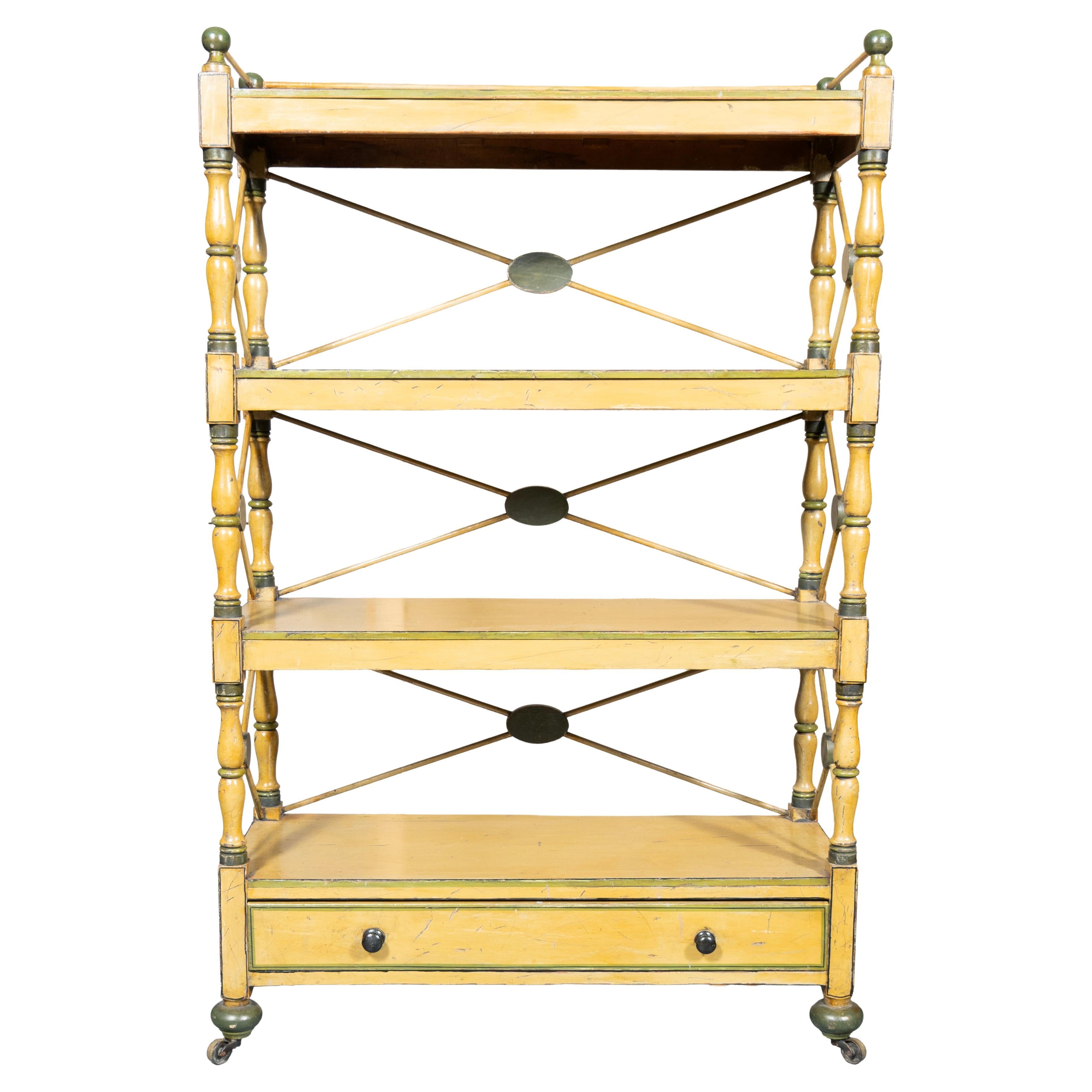 Ripiano superiore rettangolare con galleria di bastoni e palline su due ripiani liberi e ripiano di base contenente un cassetto. Piedi di tupa. Rotelle in ottone. Giallo senape con accenti verdi. Lati con forma a X, estremità con patere centrali