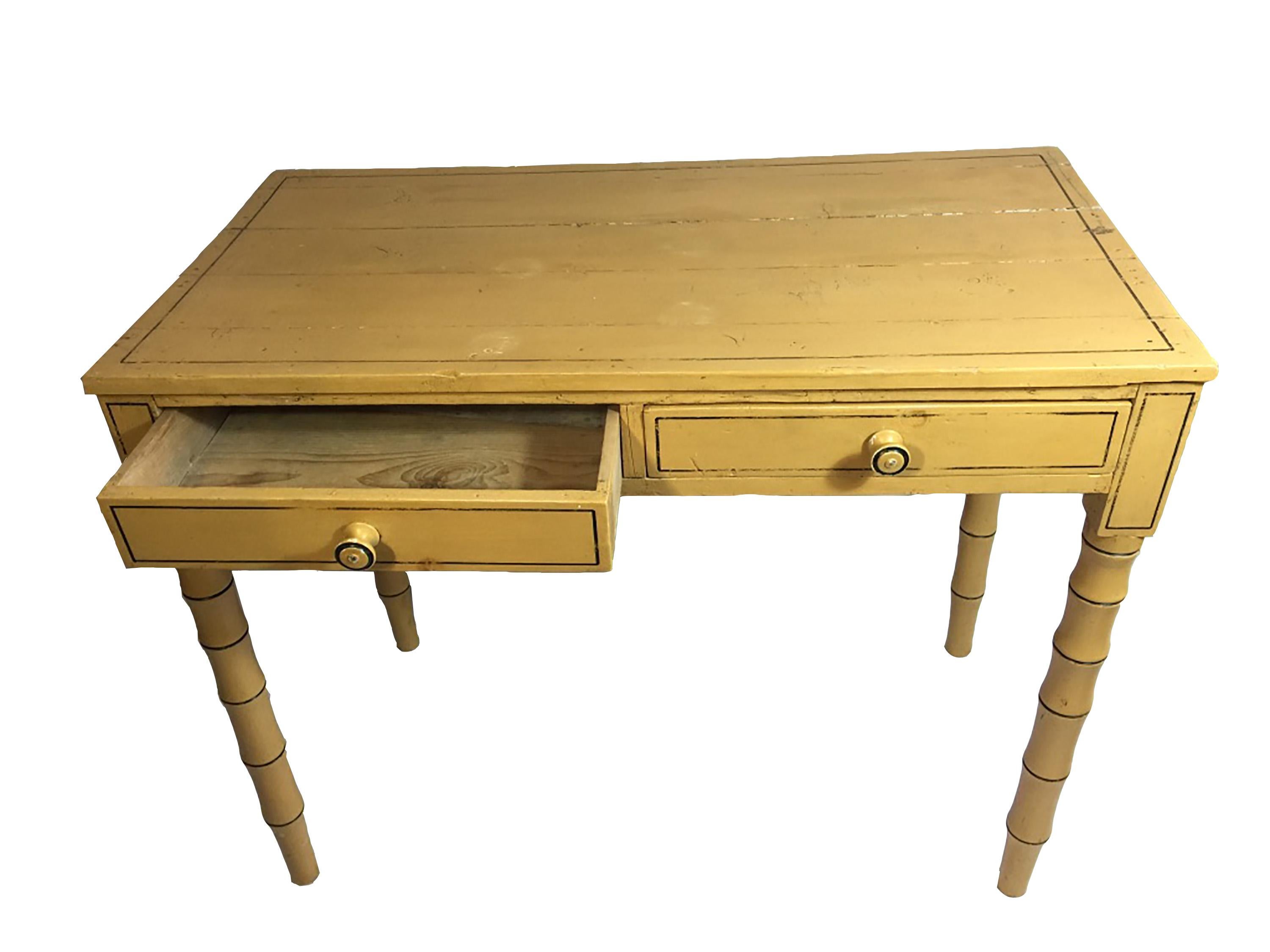 Regency yellow painted and decorated writing table with faux bamboo legs and two drawers.