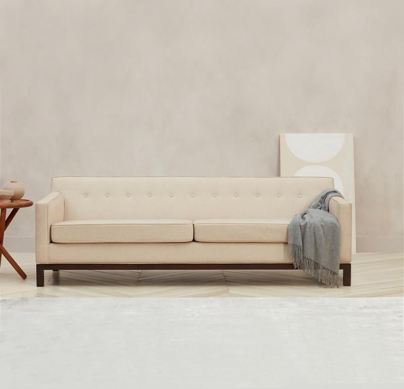 Regeneration sofa #1 which is a button backed two-seat sofa with foam seat, in the style of Dunbar. This sofa is available as a floor model as shown.