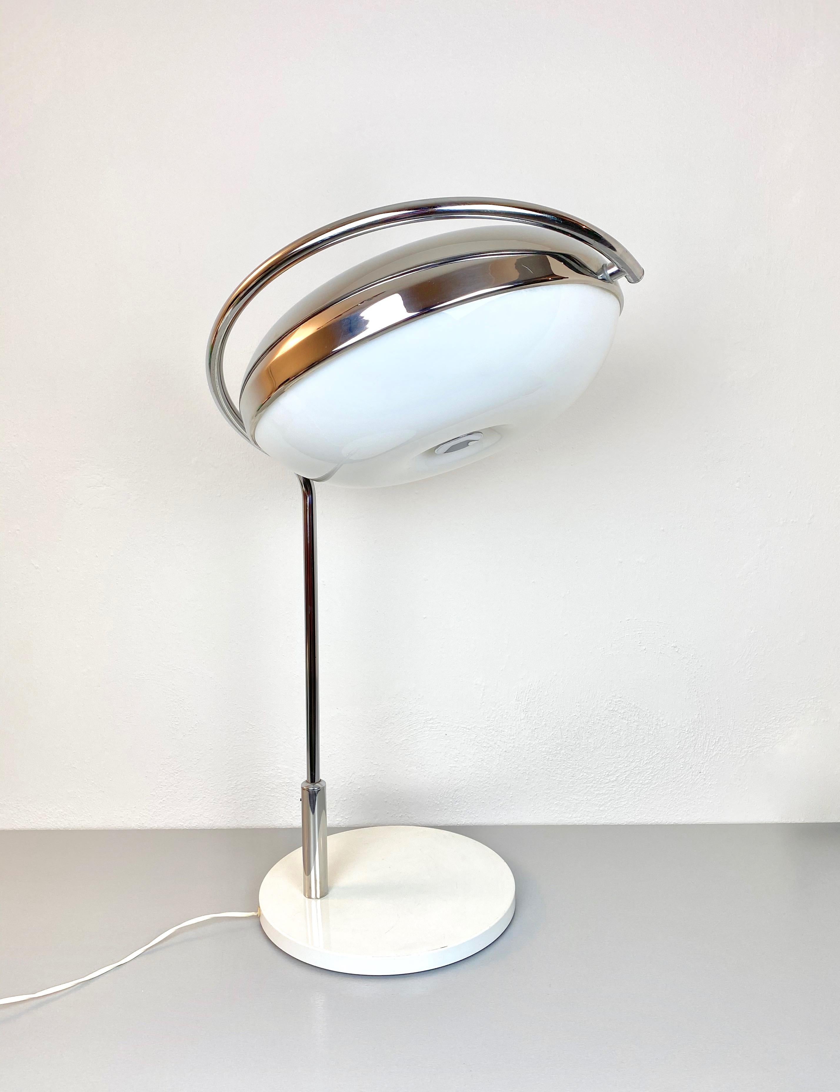Grande lampe de table en chrome et plexiglas du designer italien Reggiani, années 1970. 
La direction de la lumière peut être ajustée selon les besoins. 

Signé sur le bas 