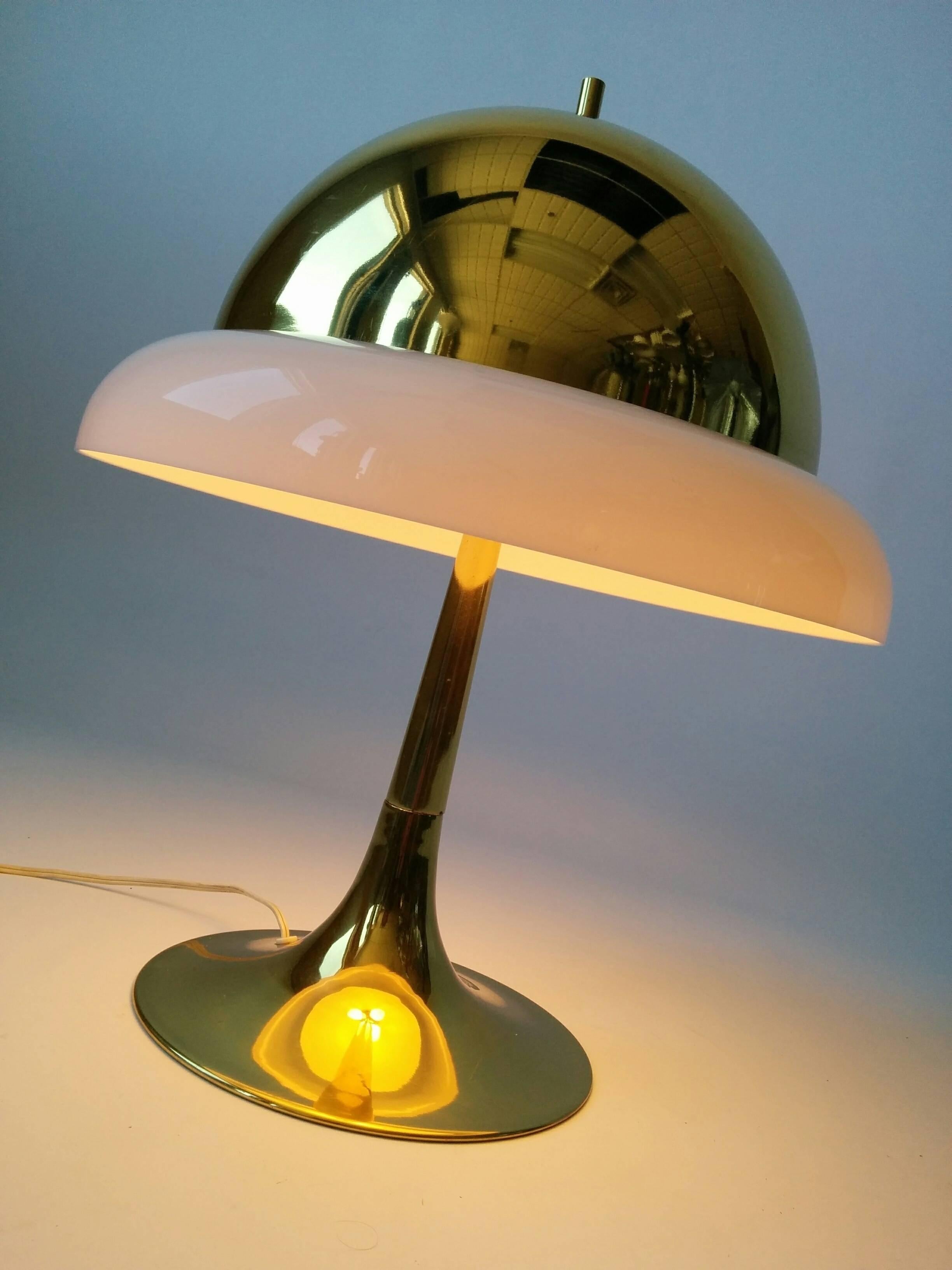 Lampe de table confortable en laiton avec un anneau extérieur en plexiglas reposant sur le bord de l'abat-jour, ce qui lui confère une sensation de chaleur et d'intimité.

Trois douilles de taille candélabre.