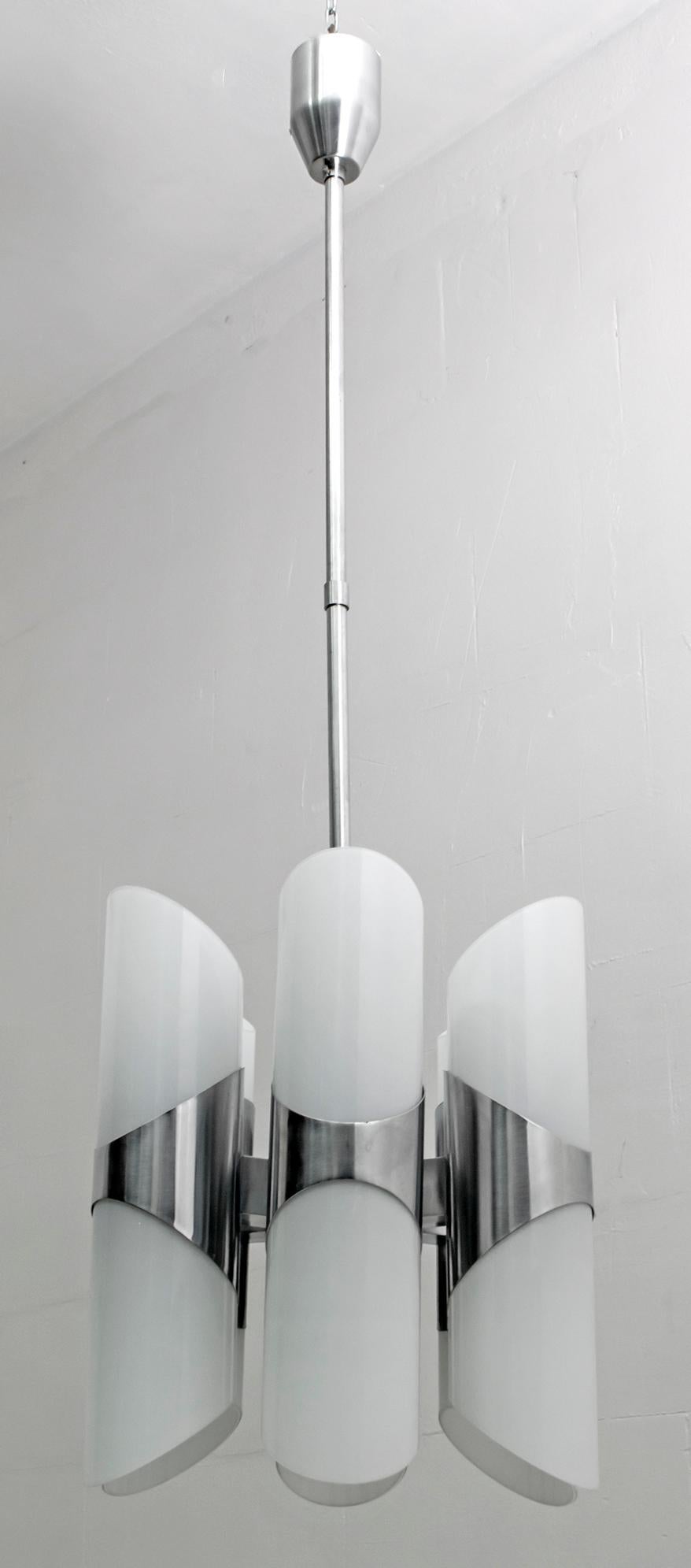 This Italian chandelier produced by the Reggiani company of Goffredo Reggiani, is from the 1960s, the cylinders in transparent Murano glass and white interior, were created with the technique of 