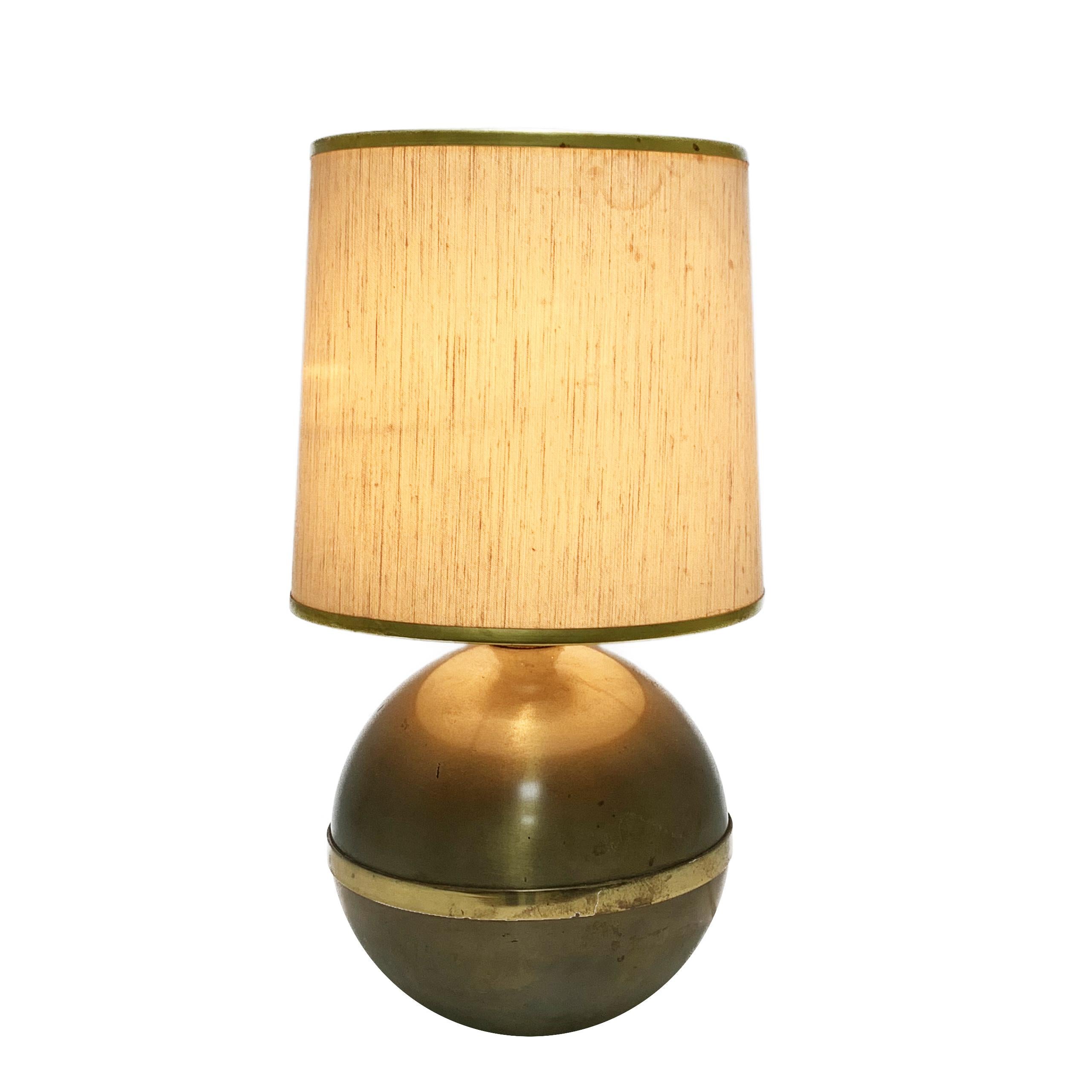 This large table light was designed and produced by Reggiani in the 1970s. It has a spherical base in metal and brass, and features the original shade.