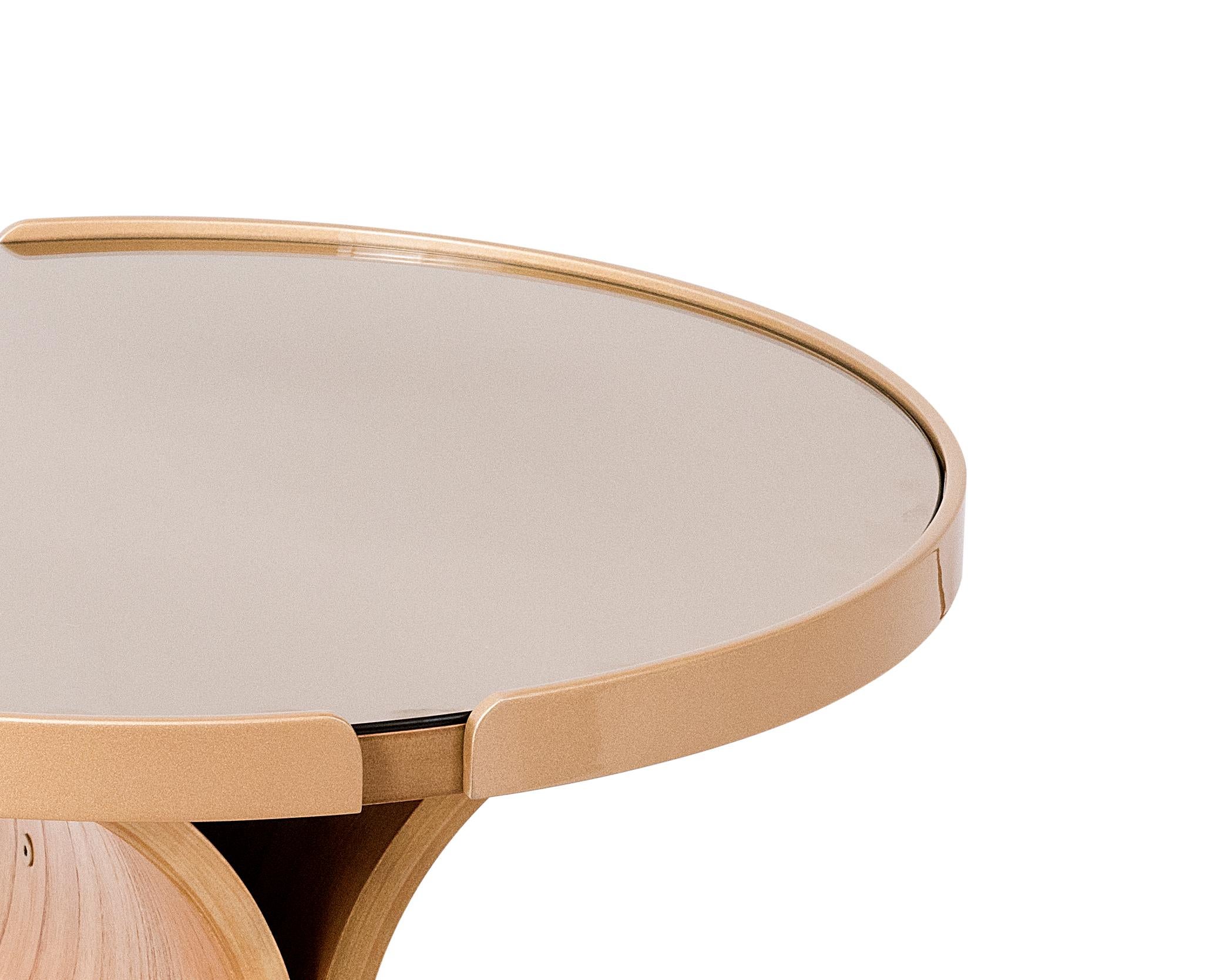 The Regia center table has a base made of a curved cinnamon natural wood multi-laminate. (20mm thick)
The top is made of MDF with wood laminate, and there is a mirror in bronze color. In the top edges there are two semi circles made of carbon steel