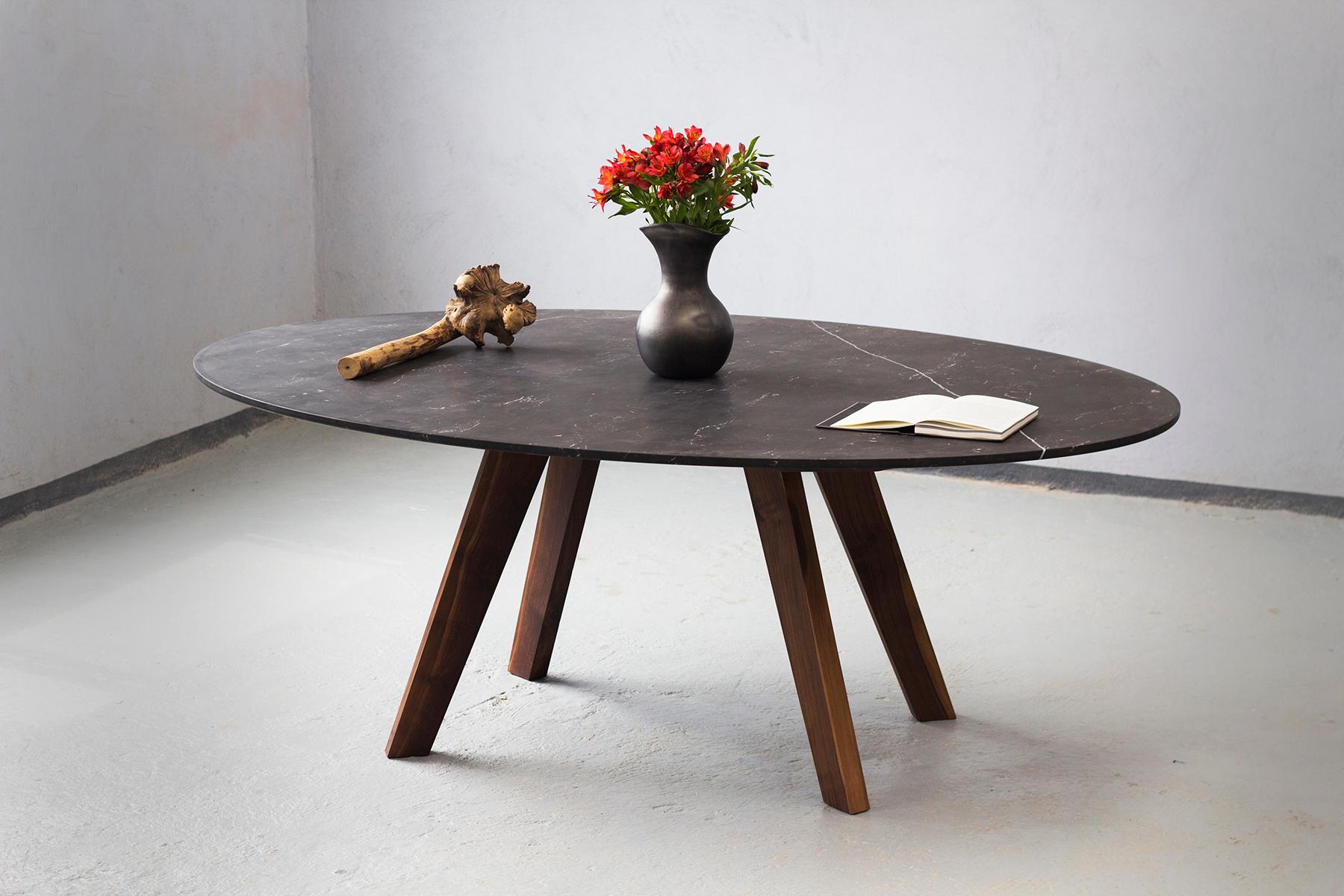 Esta mesa de comedor ovalada presenta un elegante tablero de granito, que aporta una sensación de sofisticación y durabilidad. Su base está formada por cuatro patas de madera maciza, cuidadosamente diseñadas para ofrecer estabilidad y un toque