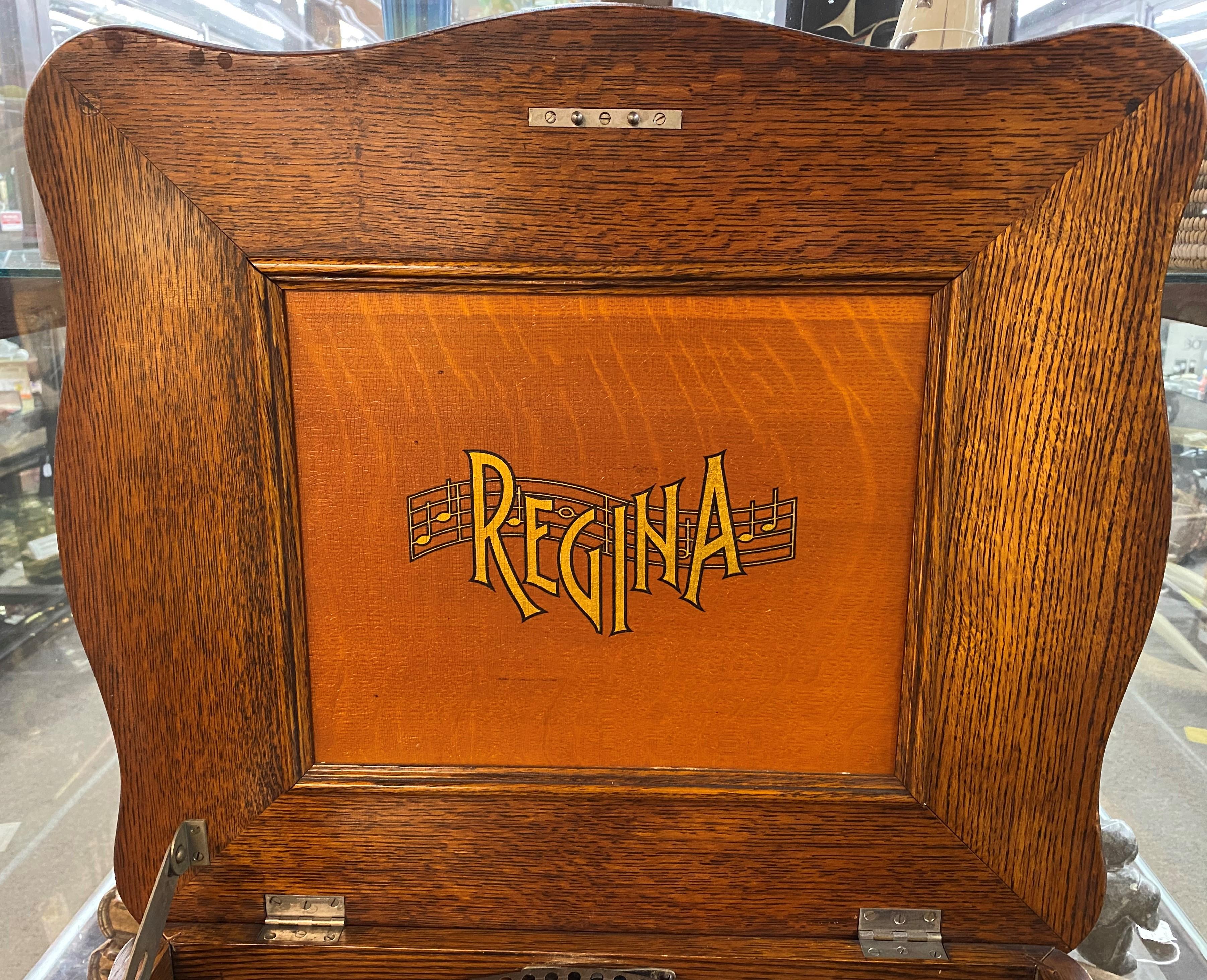 A great example of a Regina music box with short bedplate and double comb in a serpentine oak case, from the Regina Company in Rahway, NJ, Serial #5000764, and includes 10 15.5 inch song discs. A large Regina musical label appears inside the lid,