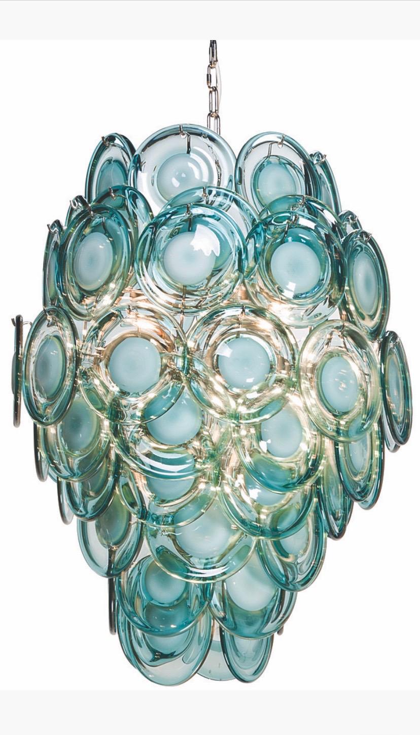 Des disques en verre en forme de gouttes, de couleur aqua, avec un centre laiteux, sont délicatement disposés en couches sur le lustre Diva, créant une magnifique lueur chaude.
Suspendez-le dans une chambre à coucher pour obtenir une lumière