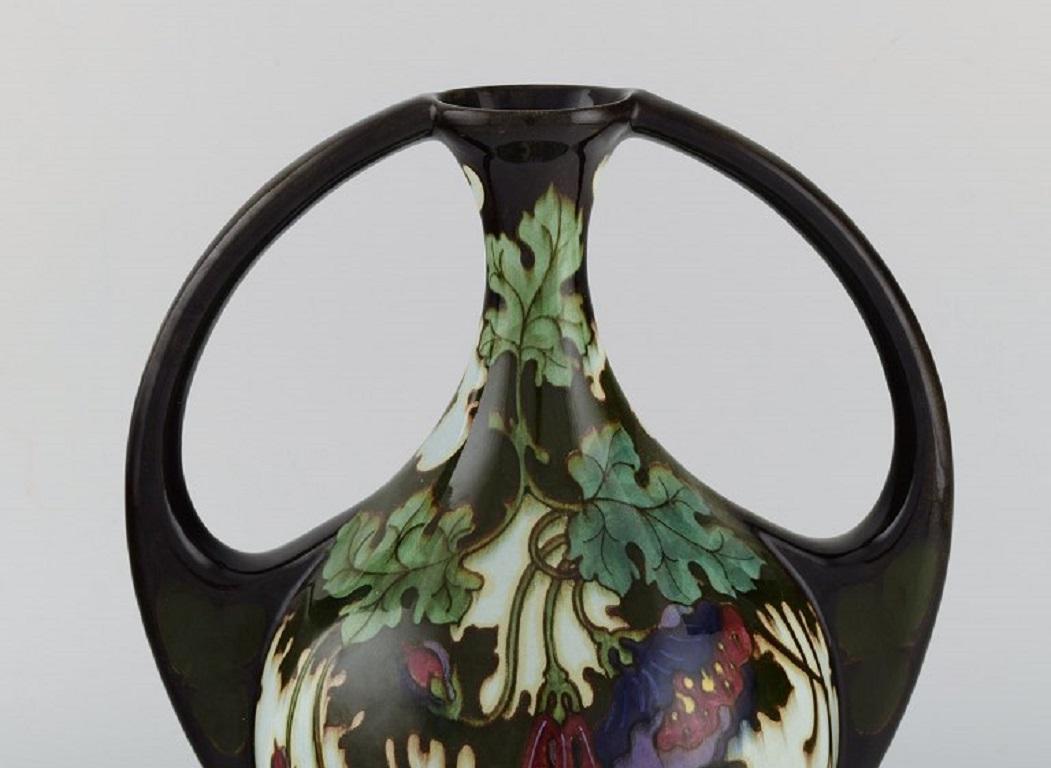 Regina, Holland. Antique Art Nouveau vase in glazed ceramics with hand-painted flowers and foliage. 
circa 1910.
Measures: 28.5 x 23 cm.
In excellent condition.
Stamped.

The Regina pottery factory, Kunstaardewerkfabriek Regina, existed from
