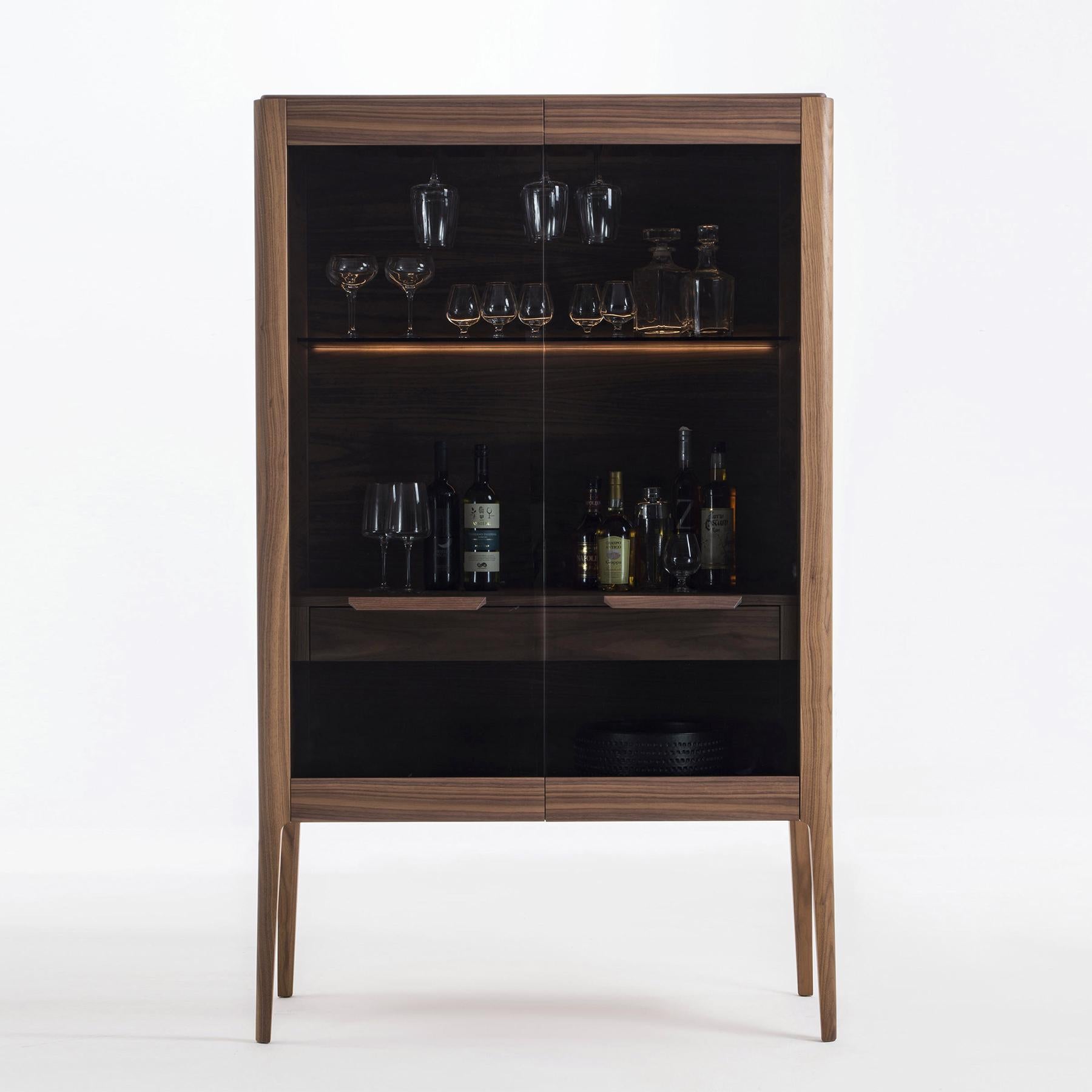 Bar Regio with all structure in solid walnut wood and with
2 smocked glass doors. With walnut shelves and glass holders,
with 2 drawers with easy glide systems. With central compartment
with LED lighted system and remote control system.