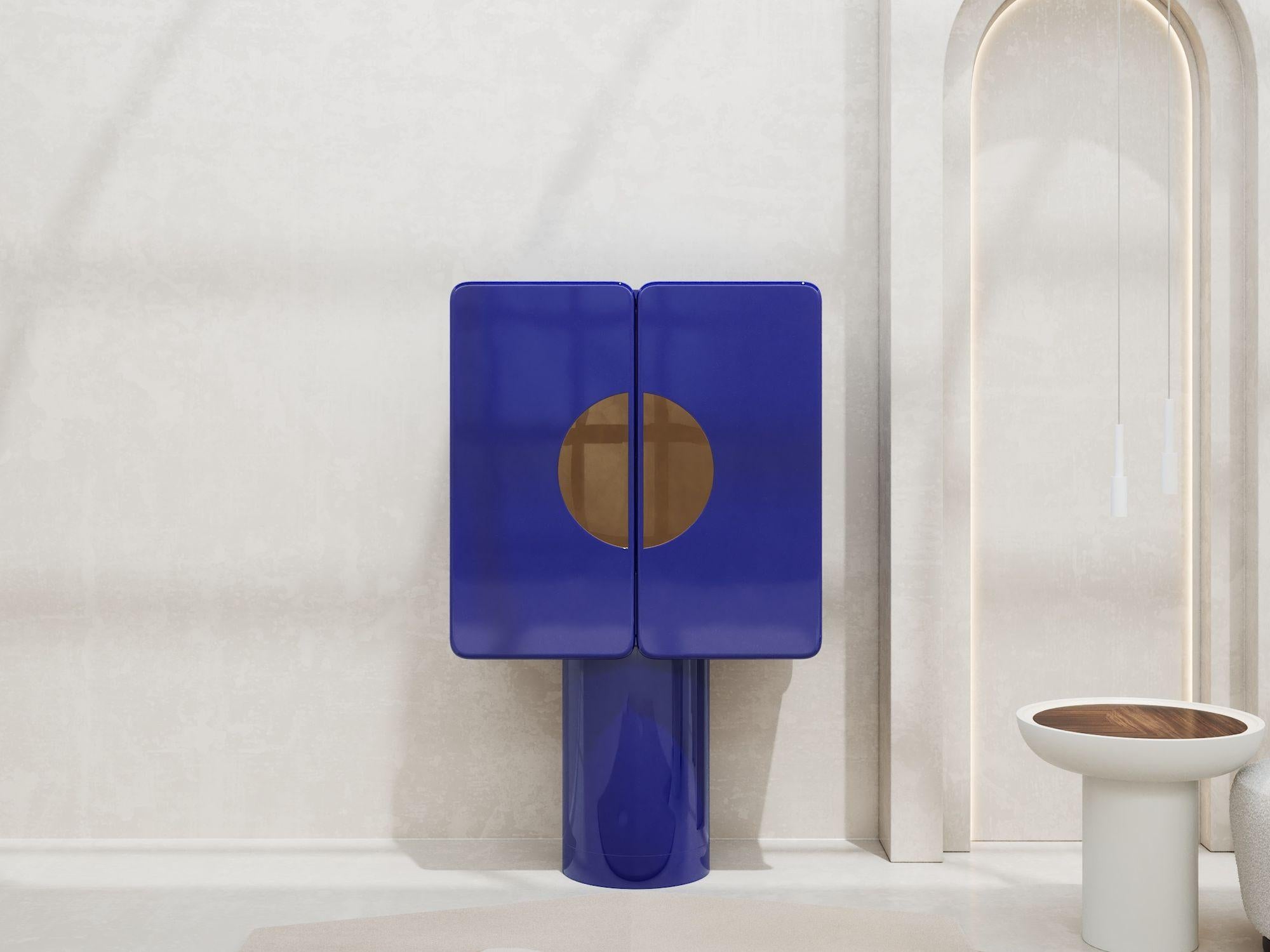 Le bleu hypnotique et inspirant d'Yves Klein nous a conduits au bleu outremer dans ce meuble bar spectaculaire.
Meuble bar avec deux portes arrondies sur base cylindrique. Insertions de miroirs dorés sur les portes, l'arrière et le dessus de
