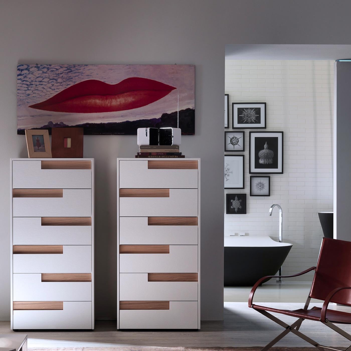 A textural decorative addition on a modern wall, this tall dresser is both functional and eye-catching. Its wooden frame boats a white matte lacquered finish that strikingly contrasts with the natural color of the off-set durmast handle on each of