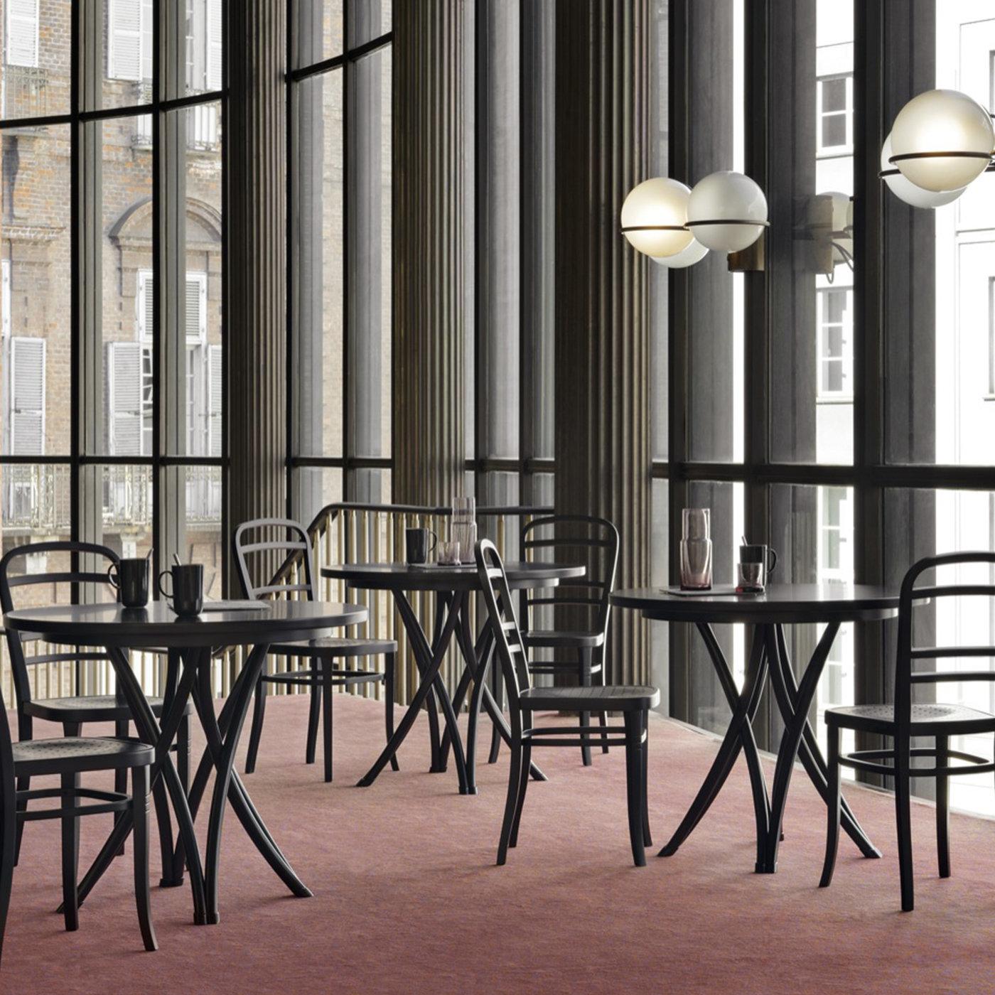 Part of the Rehbeintisch collection designed by Gebruder Thonet in 1888, this table combines a sense of lightness and movement in the elegant intersection of its slightly curved legs with a solid look that will add sophistication to any decor. The