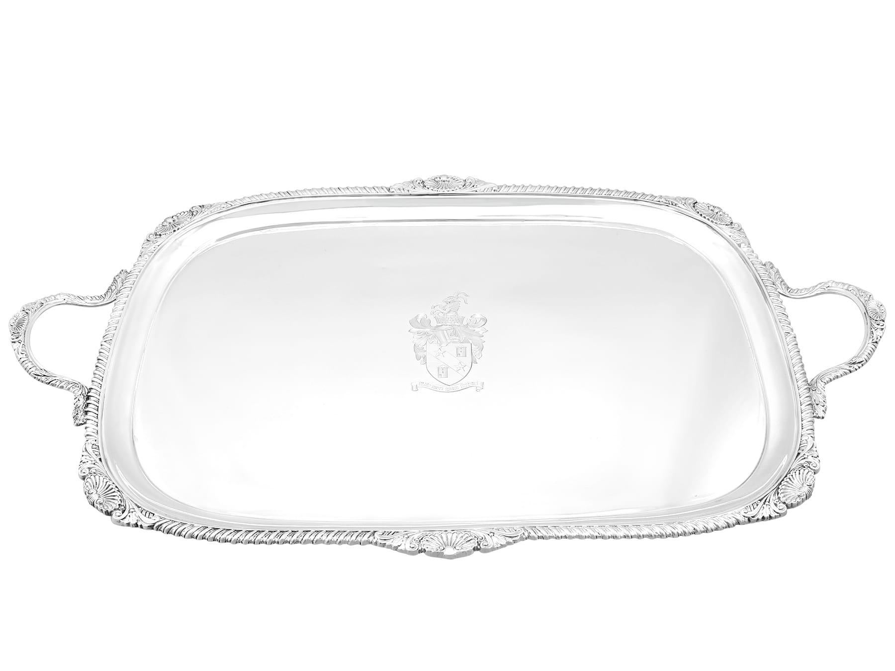 This magnificent antique Edwardian silver tray, in sterling standard, has a rectangular shaped form with rounded corners.

The surface of this sterling silver serving tray is embellished with an exceptional and impressive contemporary bright cut