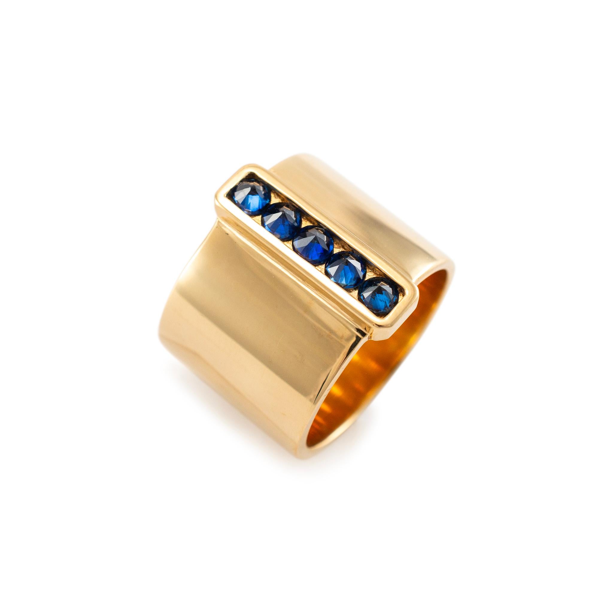 Brand: Reign

Gender: Ladies

Metal Type: 18K Yellow Gold 

Size:  6.5

Width: 14.35 mm

Weight: 17.08 Grams

18K Yellow Gold five-across sapphire band with a comfort-fit shank. The metal was tested and determined to be 18K yellow gold. Engraved
