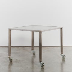 Reinforced glass and stainless steel desk on castors by Thomas Wendtland