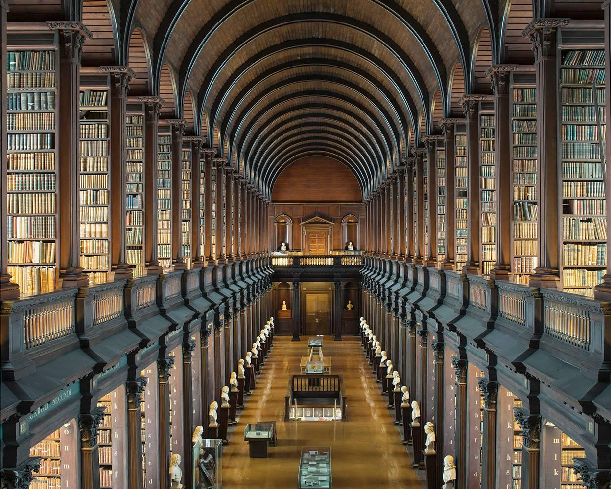 Cette photographie d'architecture à grande échelle de l'artiste allemand Reinhard Görner représente la Long Room, une vue imprenable sur l'ancienne bibliothèque du Trinity College à Dublin, en Irlande. Le plafond voûté s'arque au-dessus, tandis