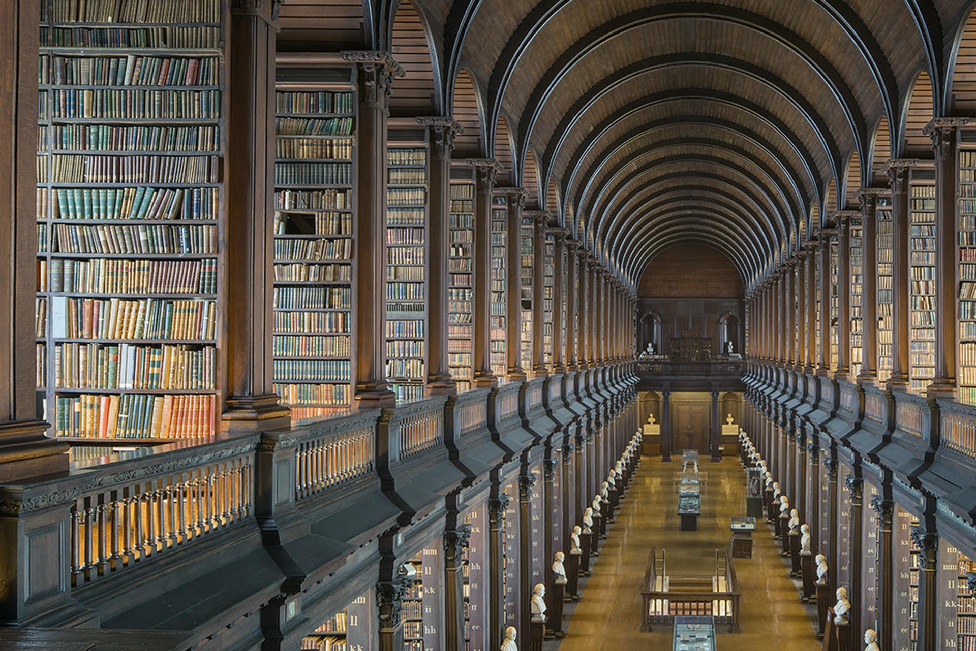 Diese großformatige Architekturfotografie des deutschen Künstlers Reinhard Görner zeigt den Langen Saal der Bibliothek des Trinity College in Dublin, Irland. Die Bögen öffnen sich wie Portale ins Innere und bringen das öffentliche Kulturerbe in den
