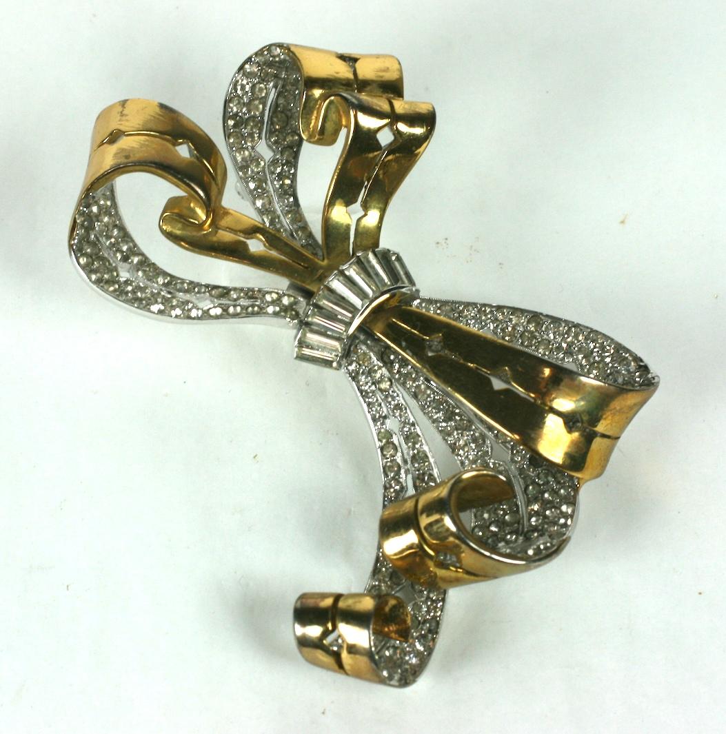 Reja massive scale Retro bow knot brooch. The Retro brooch with pierced work decoration is made of base metal with crystal rhinestone pave with 14 karat and rhodium plating.
The center knot of tapered crystal baguettes. 1940's USA.
Excellent
