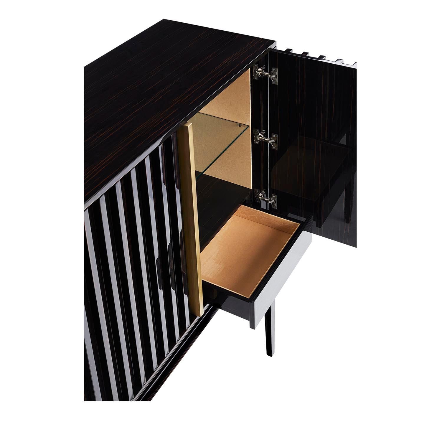 The Relevo bar cabinet is a must-have for any living room. With a modern design and incomparable quality, it will not go unnoticed in your room. The slatted structure detail and the metal handles, in brass or stainless steel, gives it a strong