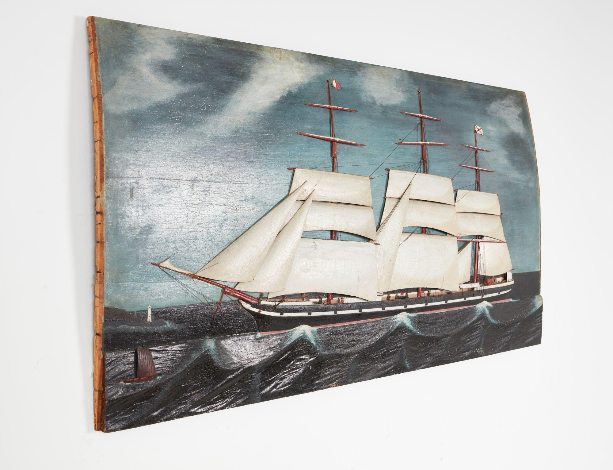 A rare relief carved and painted sailing ship on heavy board depicting a three-masted 26 gun third-class US naval frigate under partially reefed sail nearing a point of land with a lighthouse, showing in great detail sailors on board securing