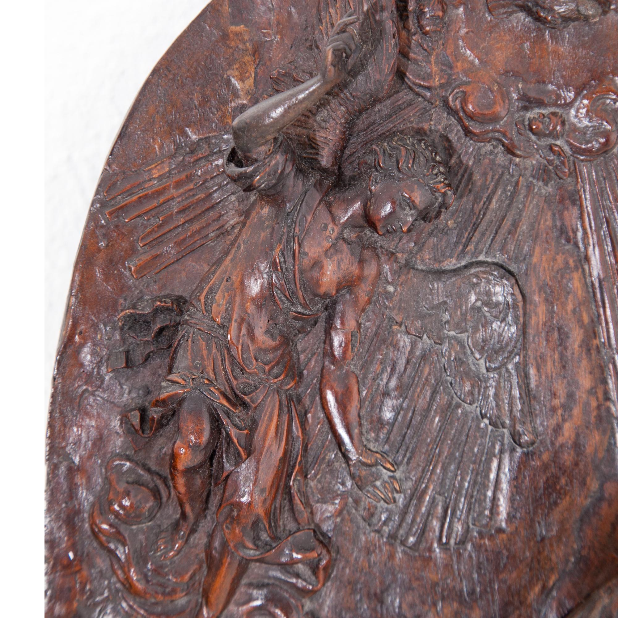 Oval, finely carved walnut relief, depicting the Annunciation of Our Lady. Archangel Gabriel’s right arm protrudes completely out of the relief, as do the hands of Mary, kneeling on a lectern. Very beautiful patina and character. prob. Southern