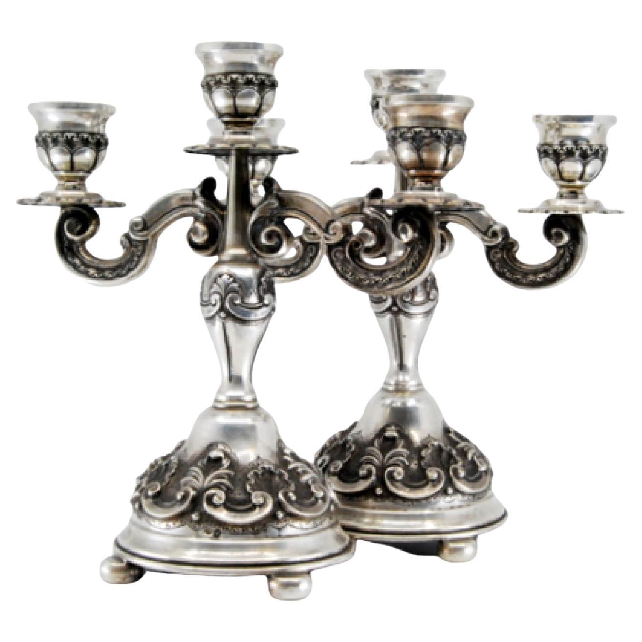 Relief silver candelabra with shells, three lights and circular bases with feet