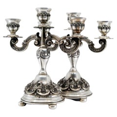 Relief silver candelabra with shells, three lights and circular bases with feet Relief silver candelabra with shells, three lights and circular bases with feet