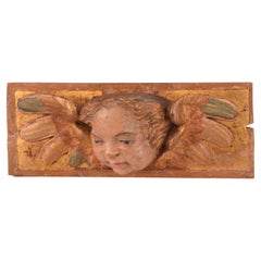 Relief with angel head. Polychrome and gilded wood. Spanish school, 16th century