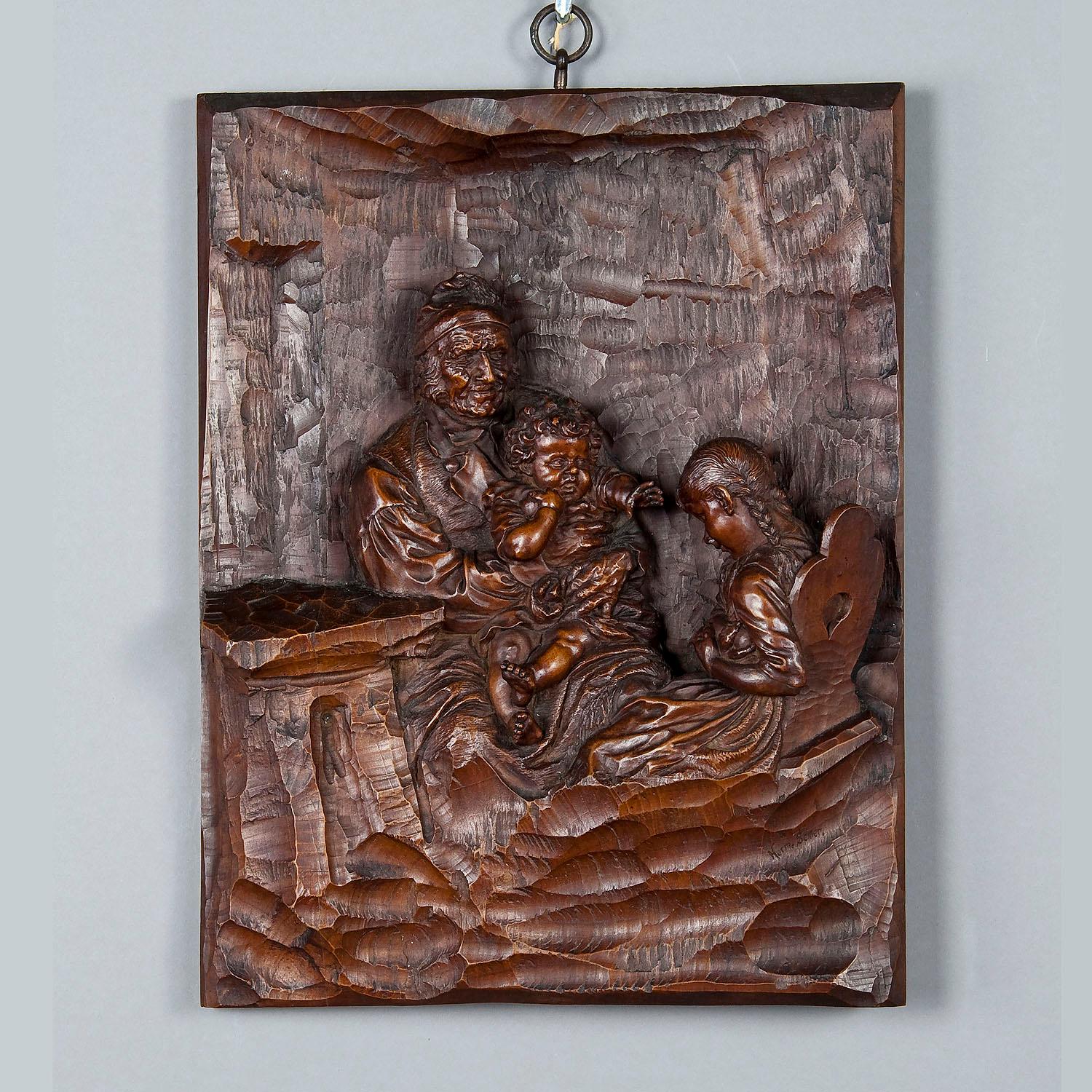 Relief Woodcarving by Hermann Steiner Meran 19th century

The wooden carved relief shows a grandfather with grandson on his lap. The granddaughter is sitting on the chair and hides a ball from her brother. Executed by the famous woodcarver Hermann