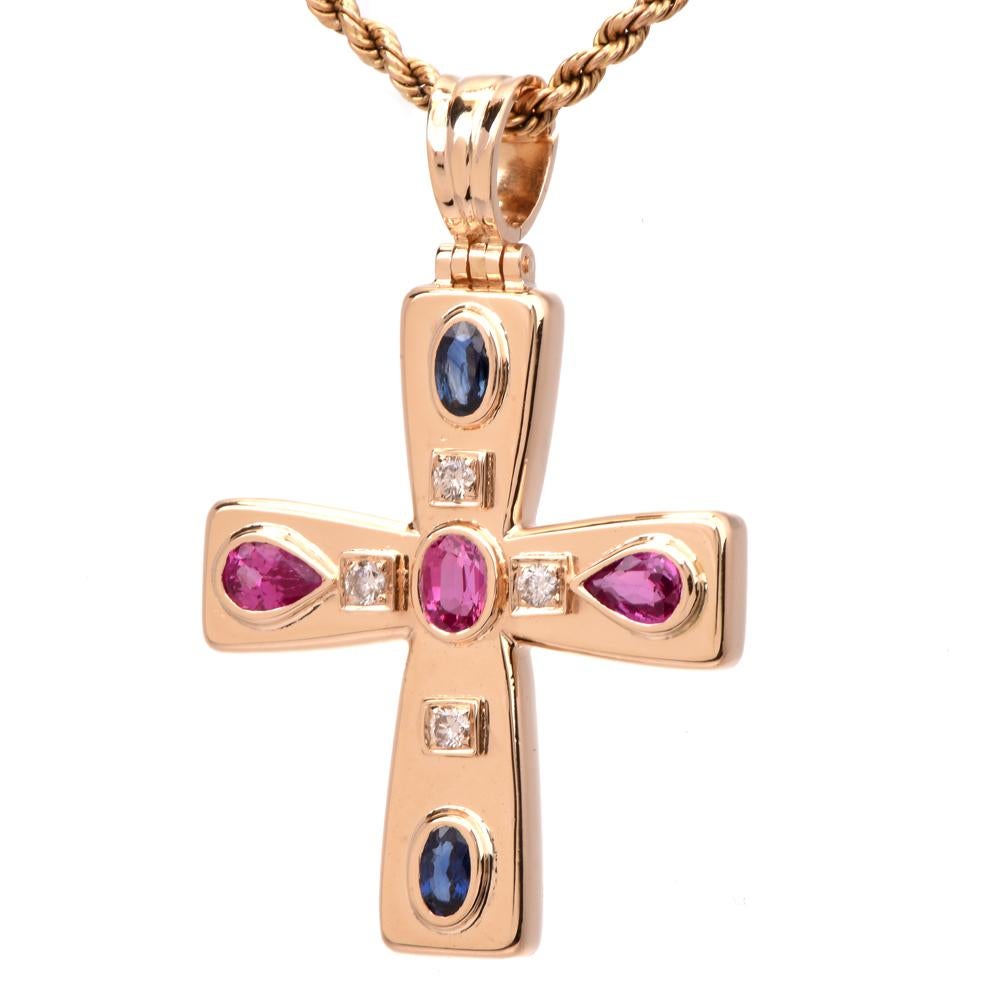 This modern multi-gem cross pendant is crafted in 18-karat yellow gold. Bezel set with four round-cut diamonds weighing approx. 0.15 carats, graded H-I color, and VS2-SI1 clarity. Along with three bezel-set pear and oval shaped pink sapphire and two