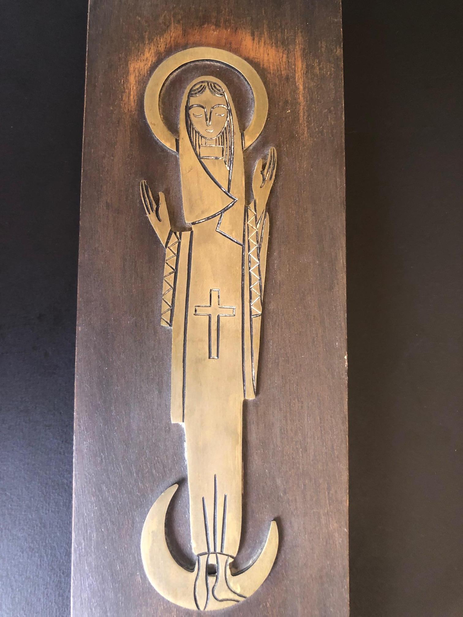 Une très belle et simple plaque ou icône religieuse de Marie, la mère de Jésus. La pièce est un bas-relief en laiton sur une plaque de bois, vers les années 1960.