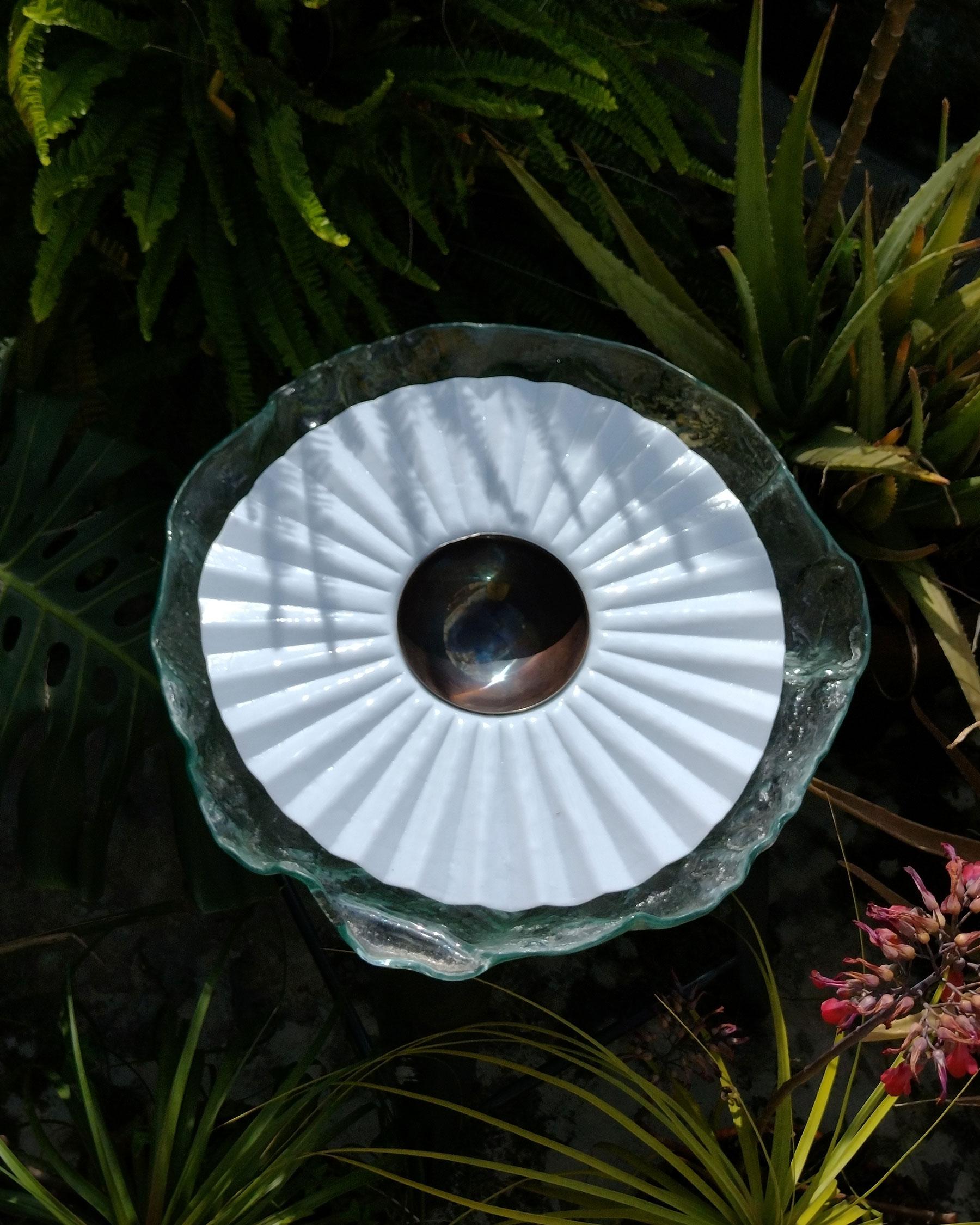 Reliquia di Ehécatl Moreno
Fatto a mano
Dimensioni: D 45 x L 45 x H 12 cm.
Materiali: Vetro, acciaio.

Un piatto di vetro modellato per termoformatura, è un capolavoro di trasparenza e luminosità. Il suo design prismatico cattura la luce in modo